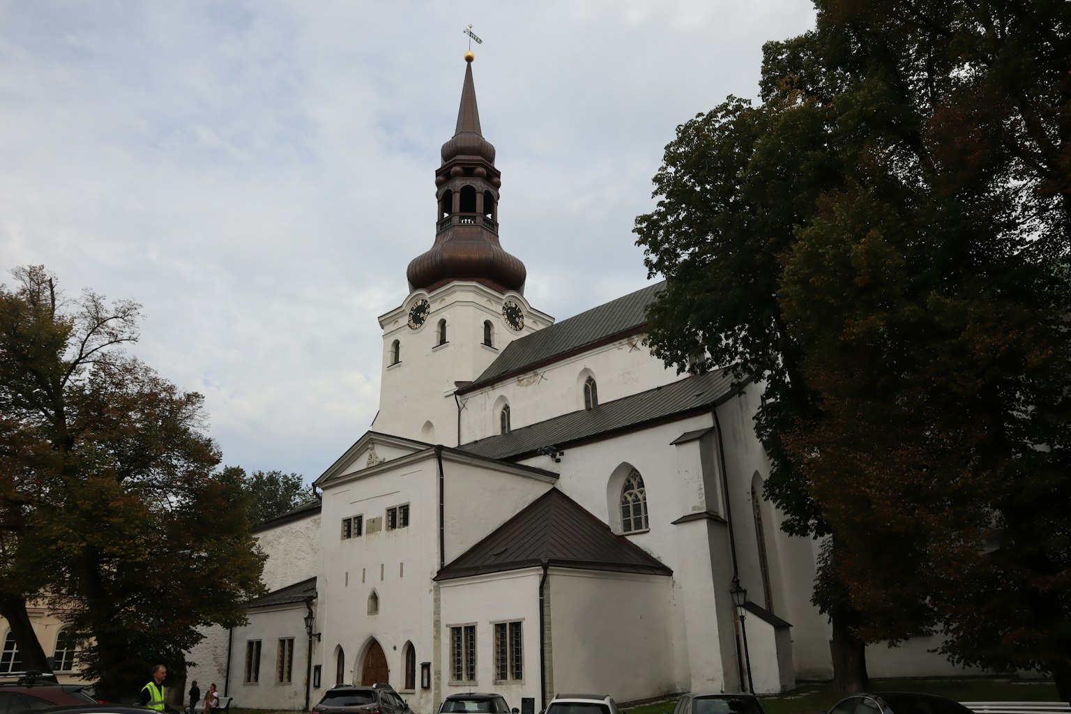 Kirche mit weißer Fassade und markantem braunen Turm