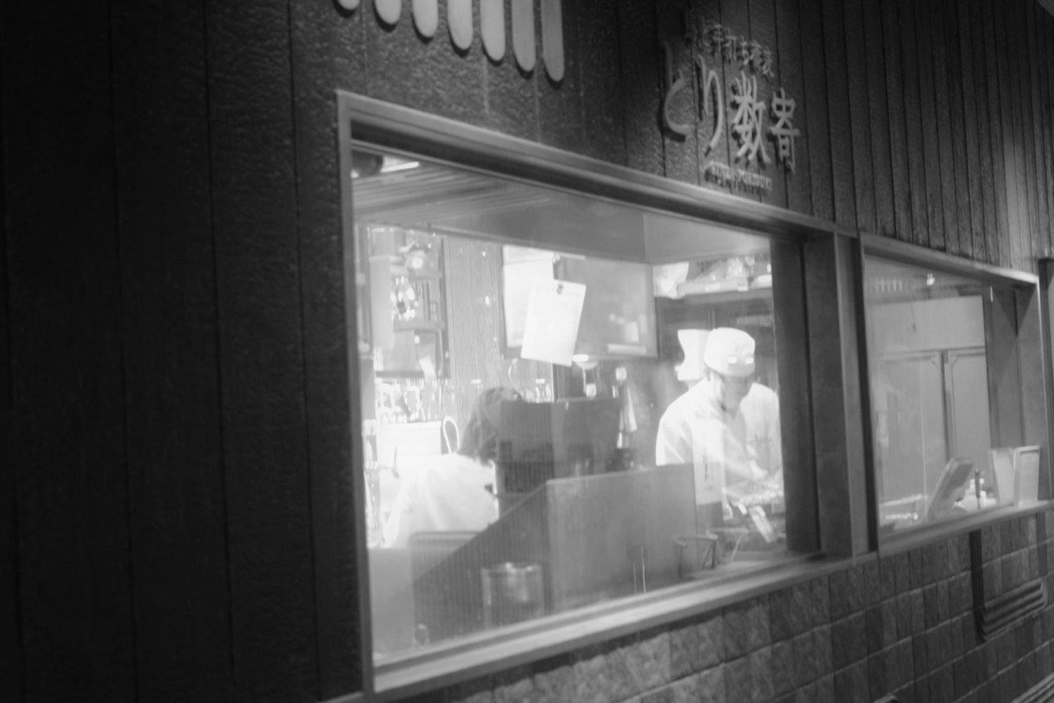 Interno di un ristorante con un cuoco visibile attraverso la finestra