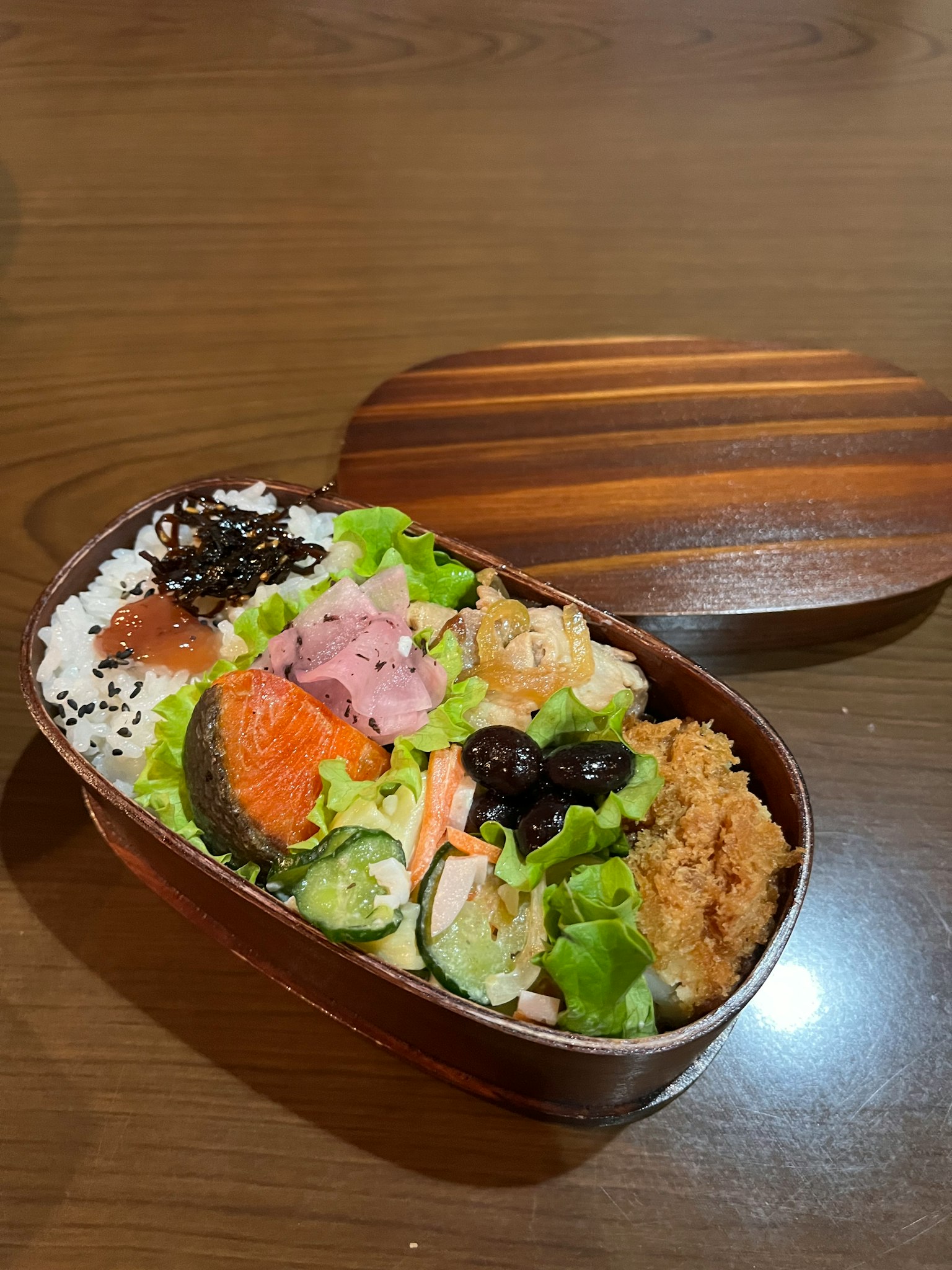 在木制便当盒中排列的多彩食材和米饭