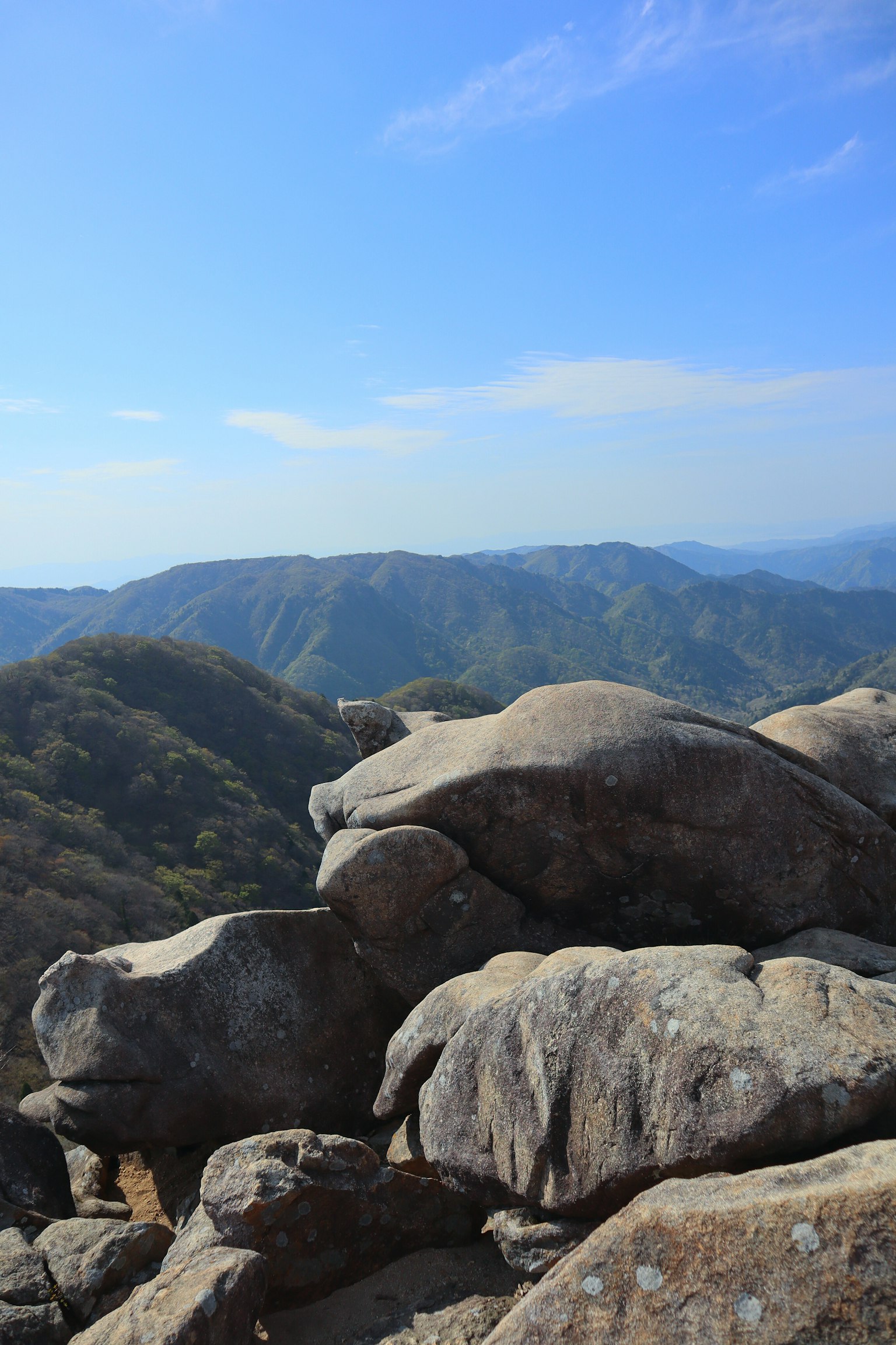 Large rocks with a mountainous landscape under a blue sky
