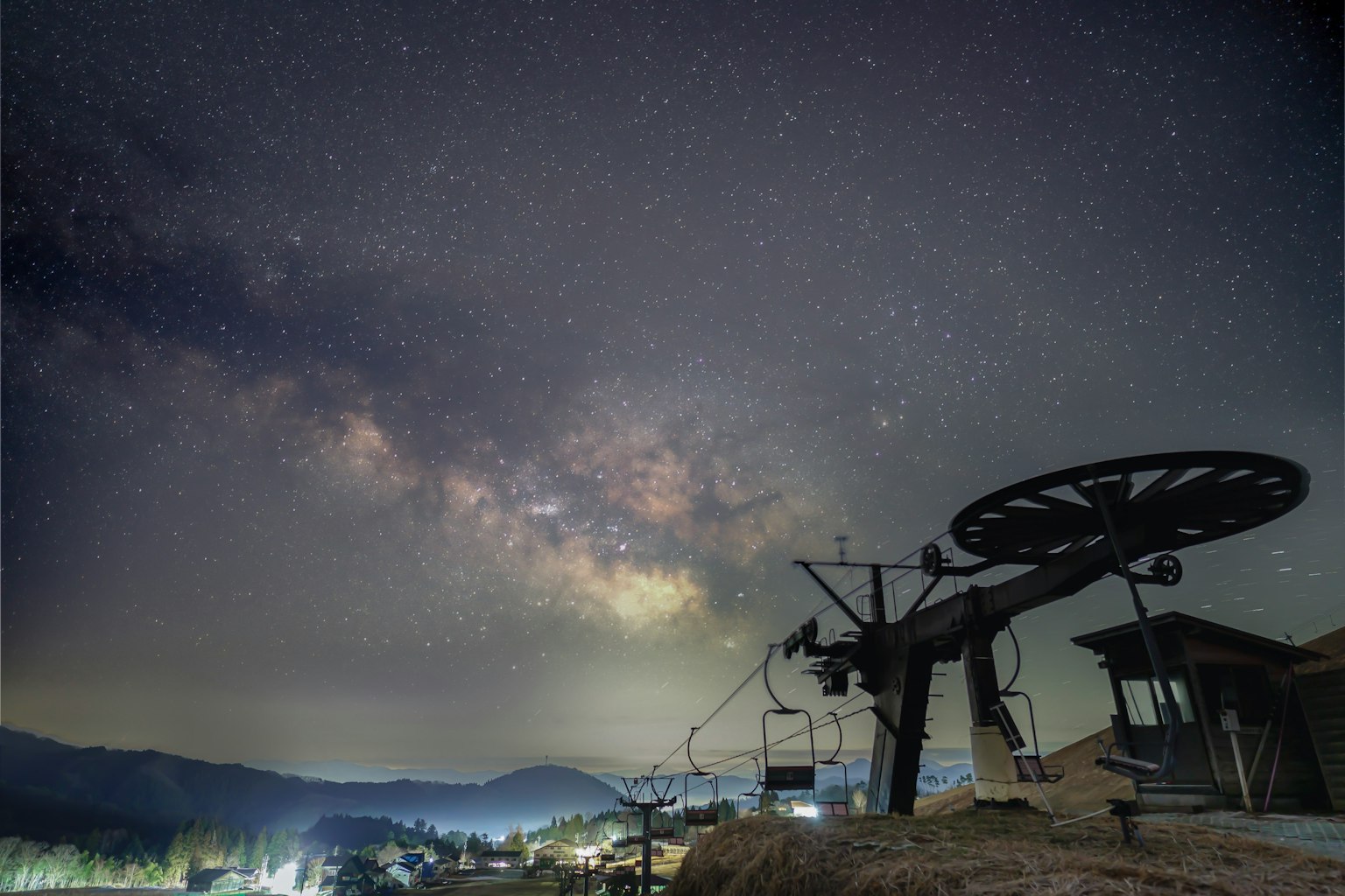 Scène nocturne avec un ciel étoilé et la Voie lactée avec une structure de télésiège