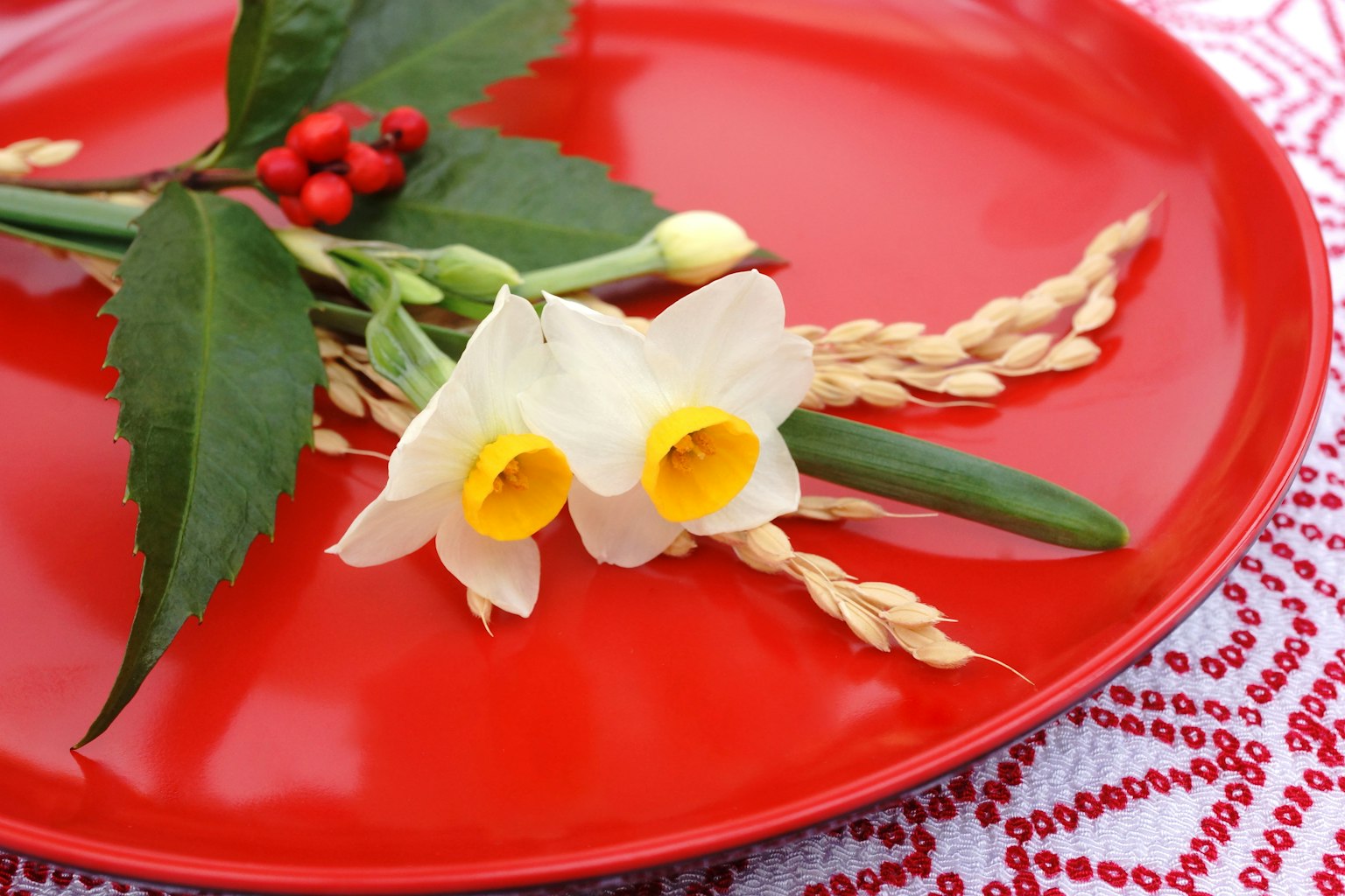 Arrangement of white flowers and green leaves on a red plate