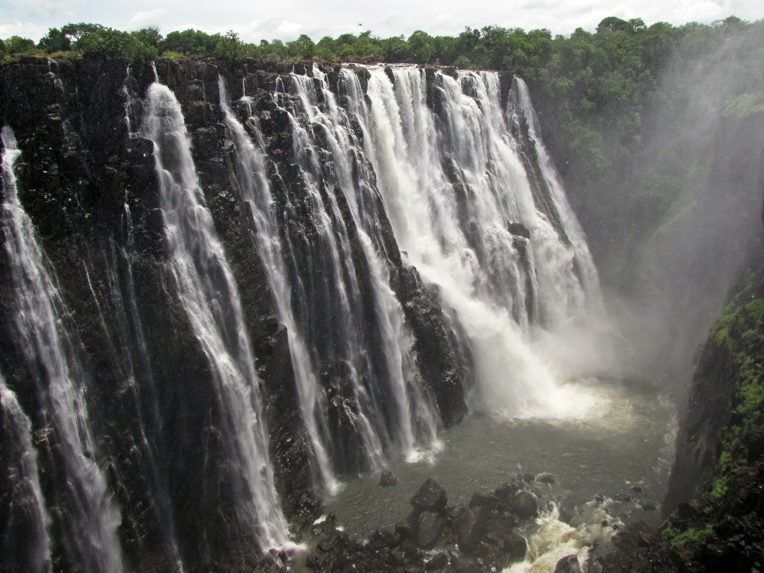 Pemandangan air terjun yang megah dengan pepohonan di sekitarnya