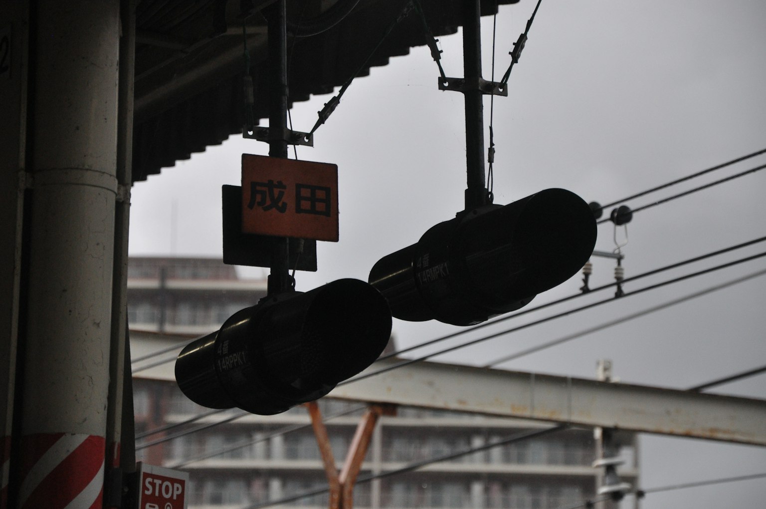 ไฟสัญญาณรถไฟแขวนที่สถานีใต้ท้องฟ้าที่มีเมฆมาก