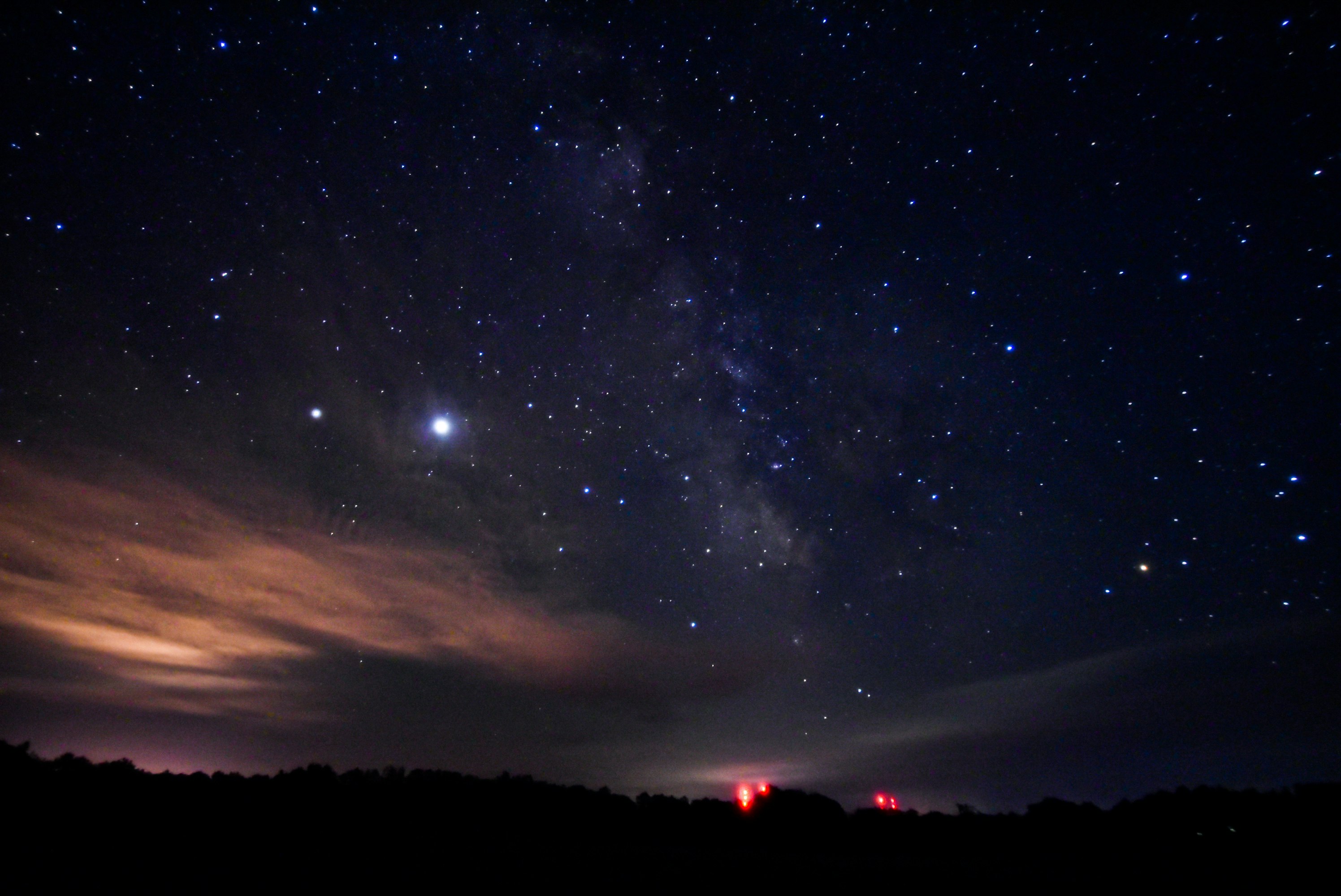 雲の間から見える星空と夜の地平線