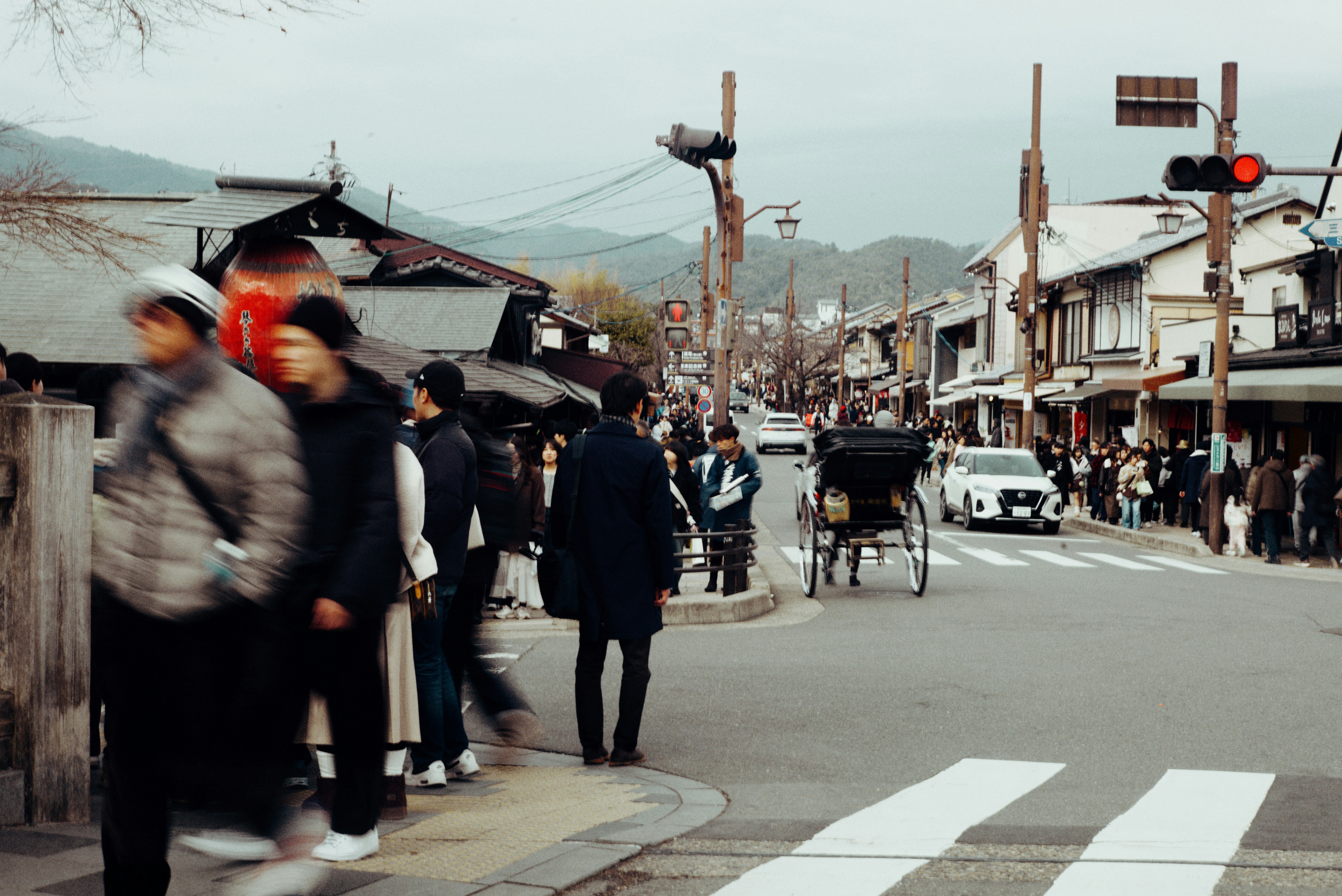 人々が行き交う伝統的な日本の街並みと横断歩道