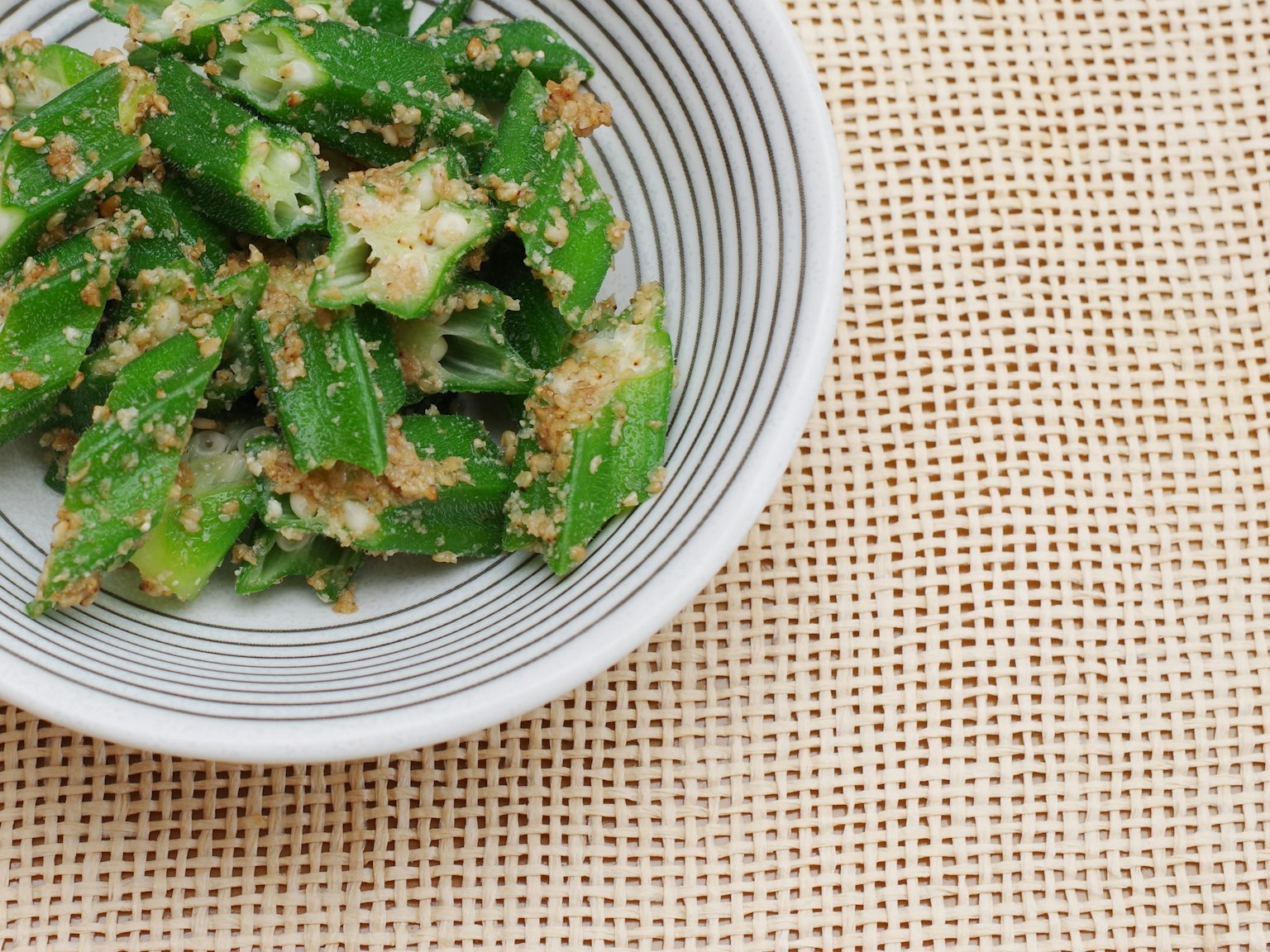 Ensalada de verduras verdes en un tazón blanco a rayas