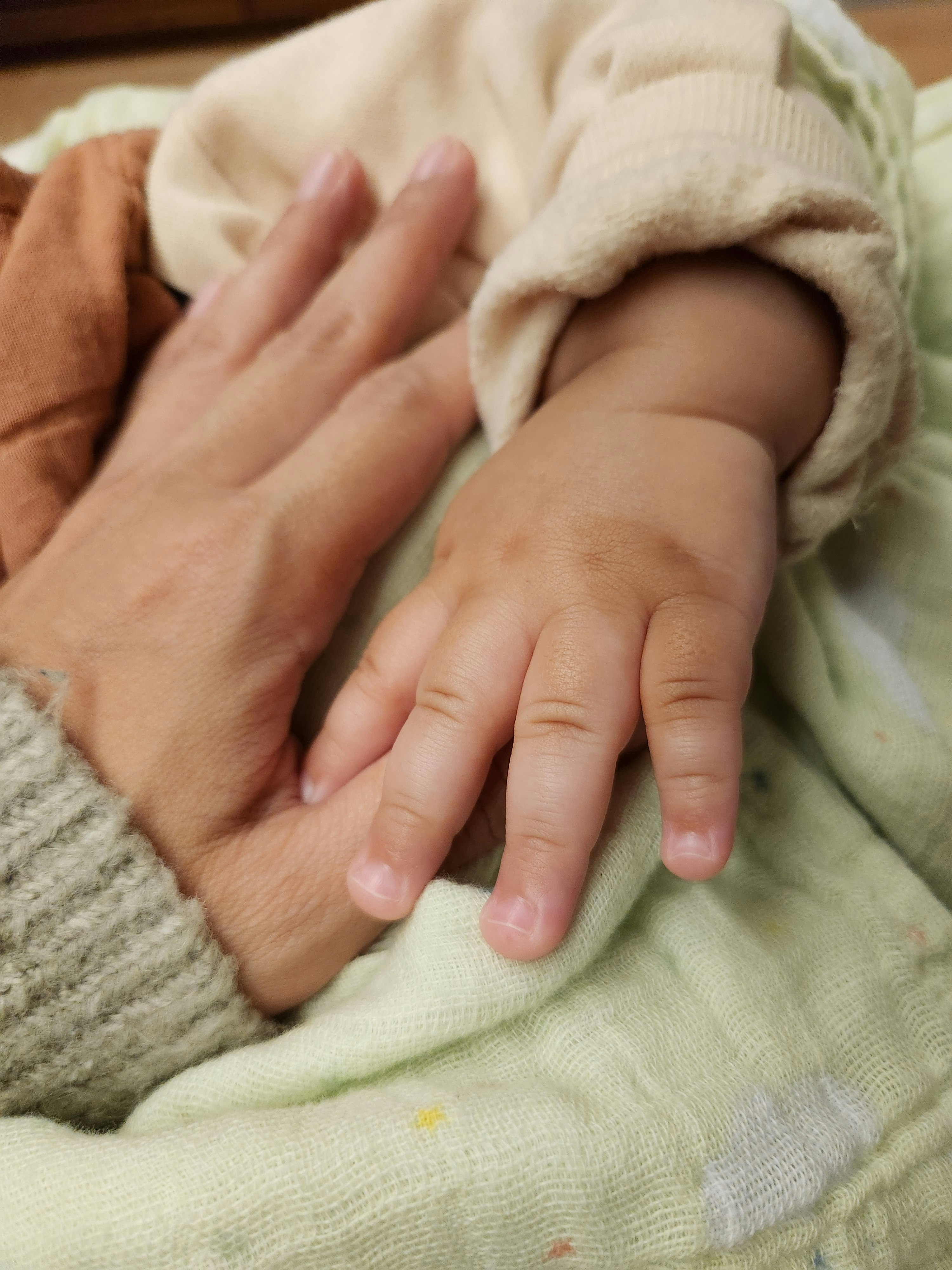 gentle hands holding a baby’s hand