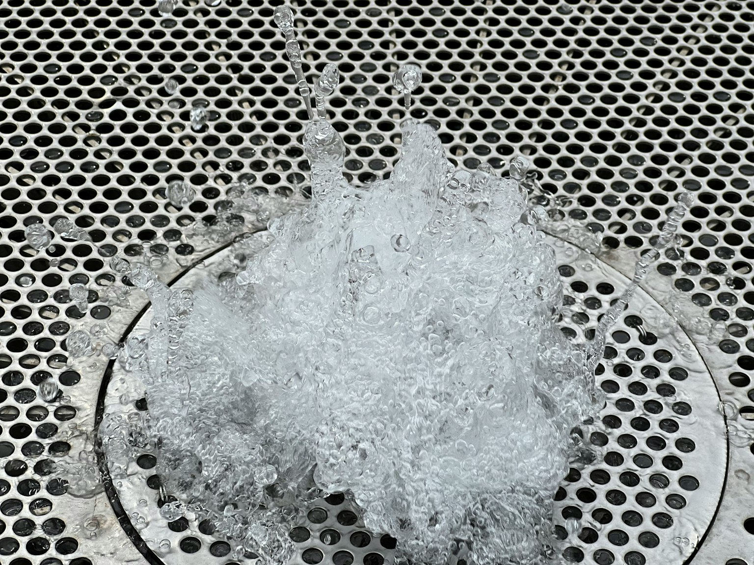 Water splashing from a fountain on a metal grate
