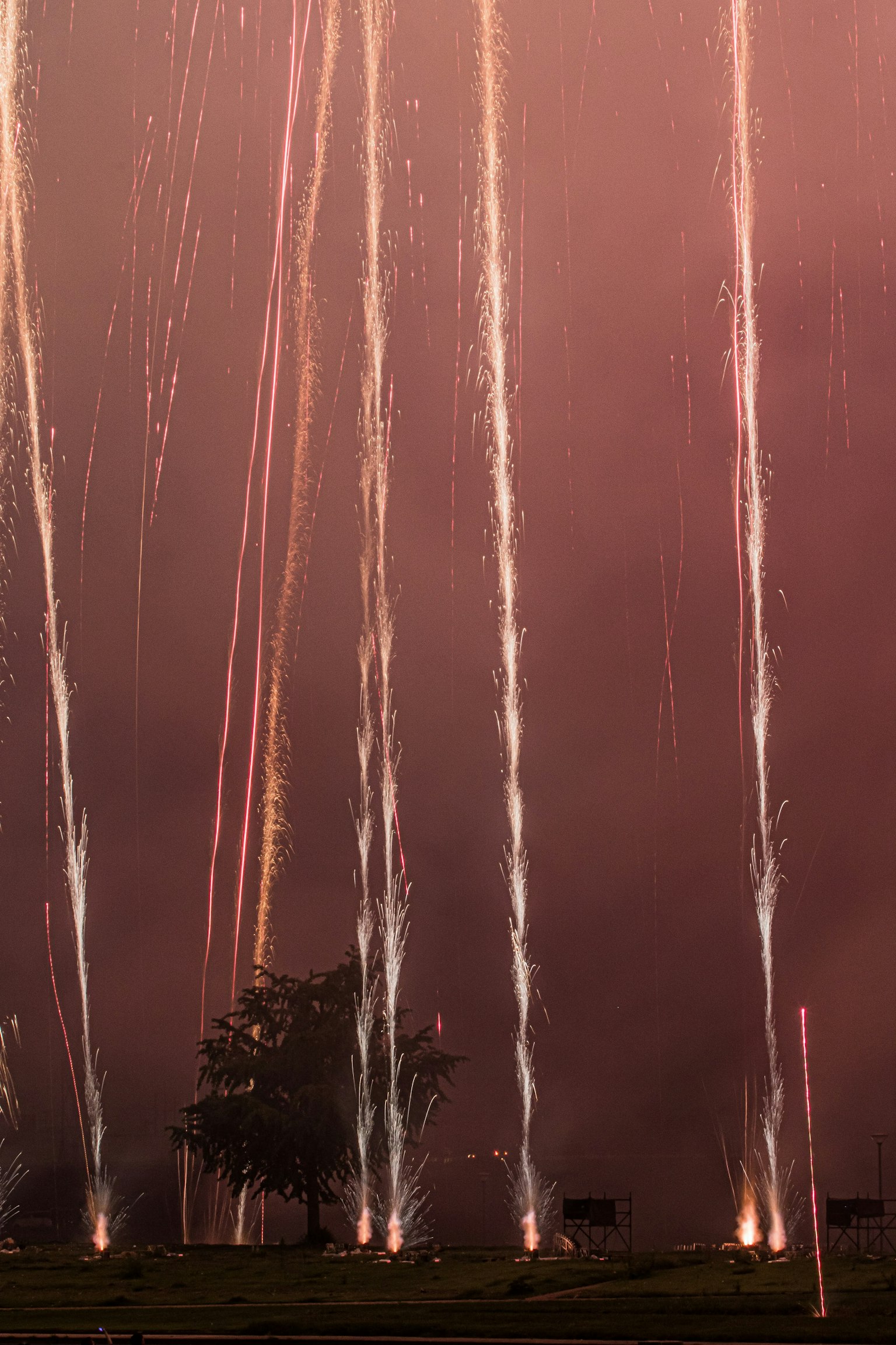 Feuerwerke, die in den Nachthimmel schießen, mit dunklen Wolken im Hintergrund