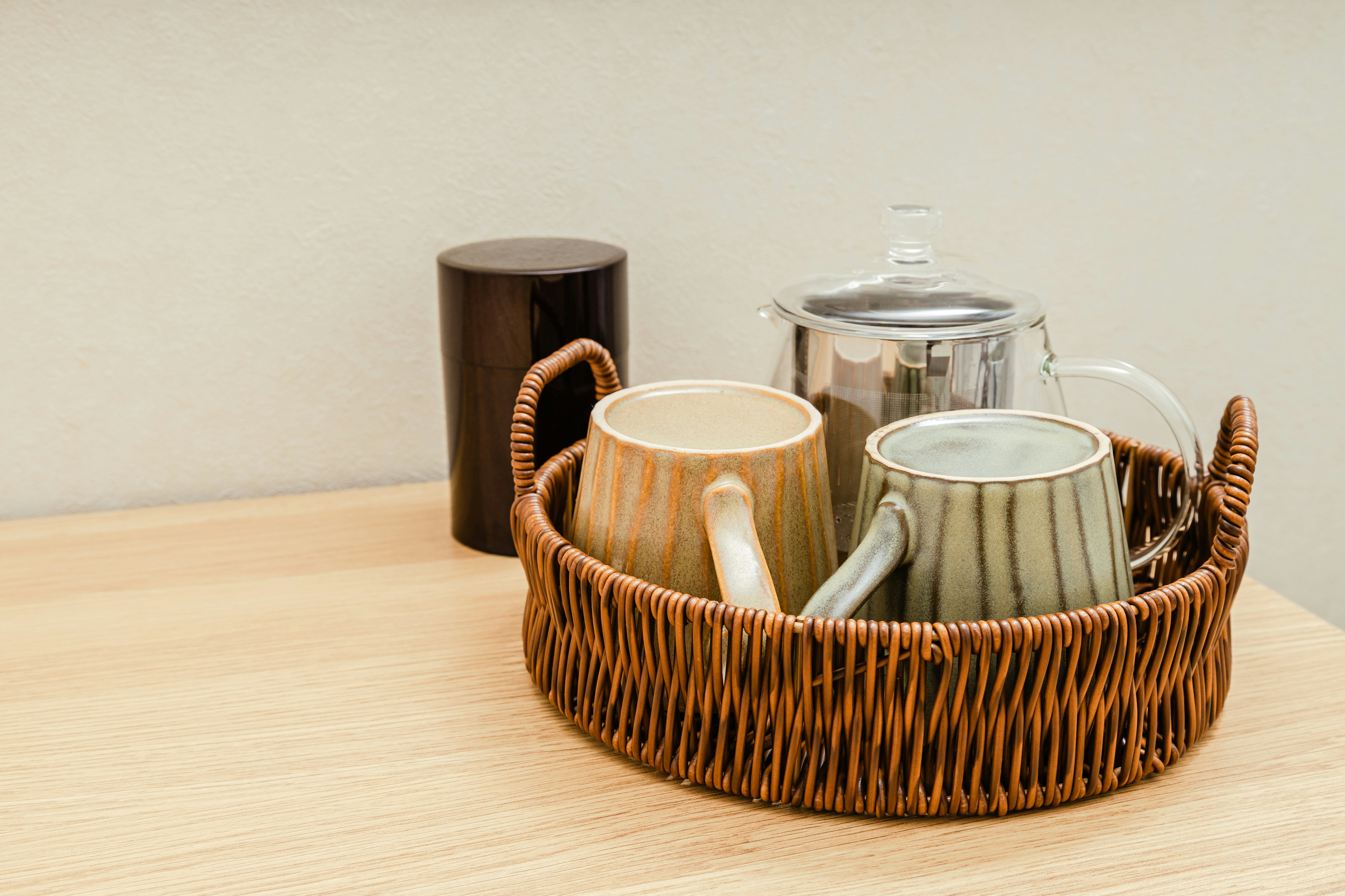 籠に入った急須と湯呑み、茶器のあるテーブル