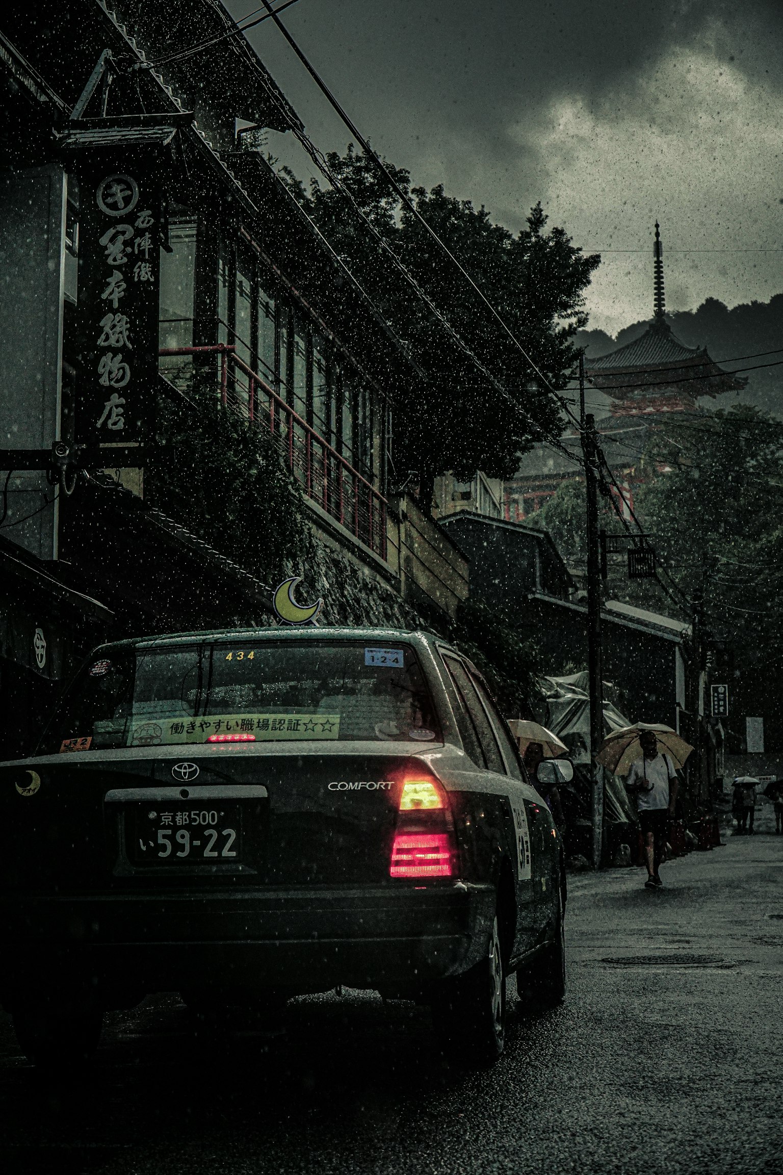 Un taxi garé dans une rue pluvieuse sous des nuages sombres