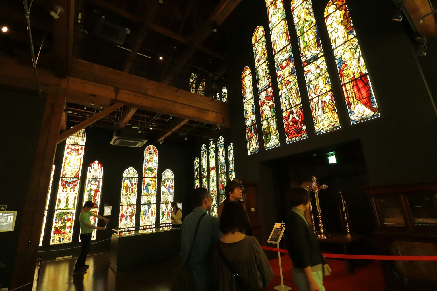 Interior museum dengan jendela kaca patri yang indah dan pengunjung yang menjelajah