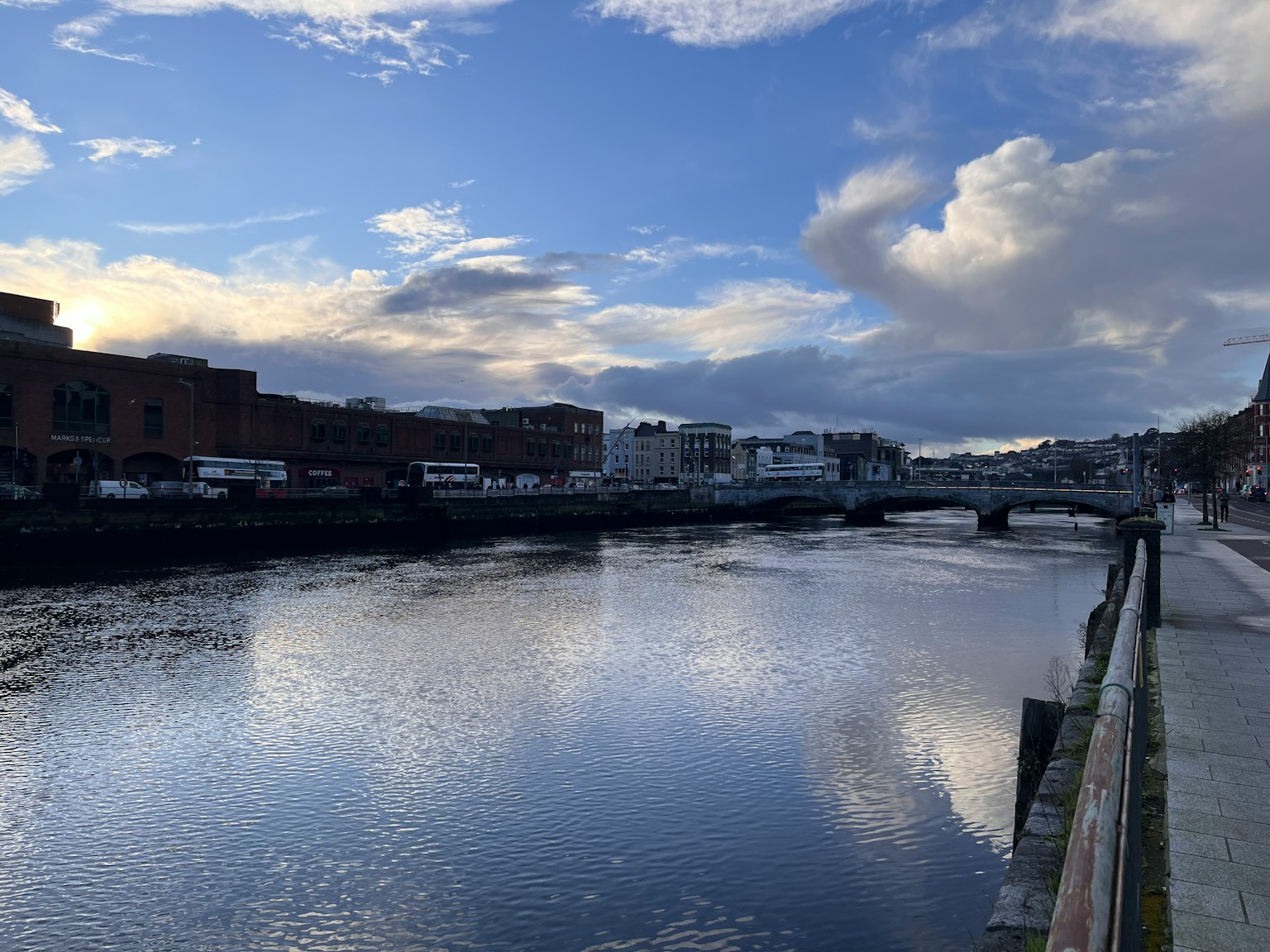 Ruhige Flusslandschaft mit blauem Himmel und Wolken, die sich im Wasser spiegeln