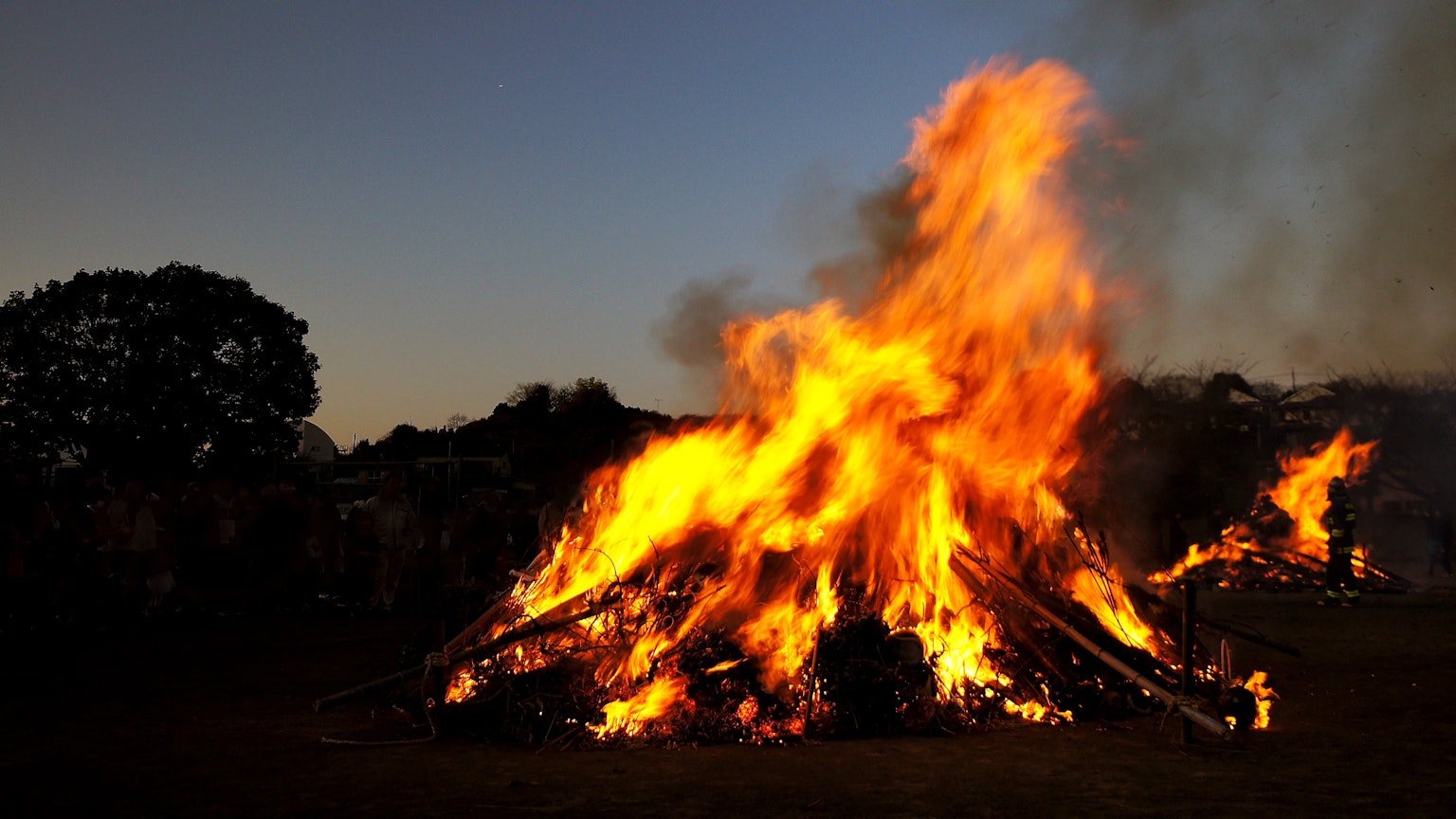 Ein loderndes Feuer gegen einen dämmernden Himmel