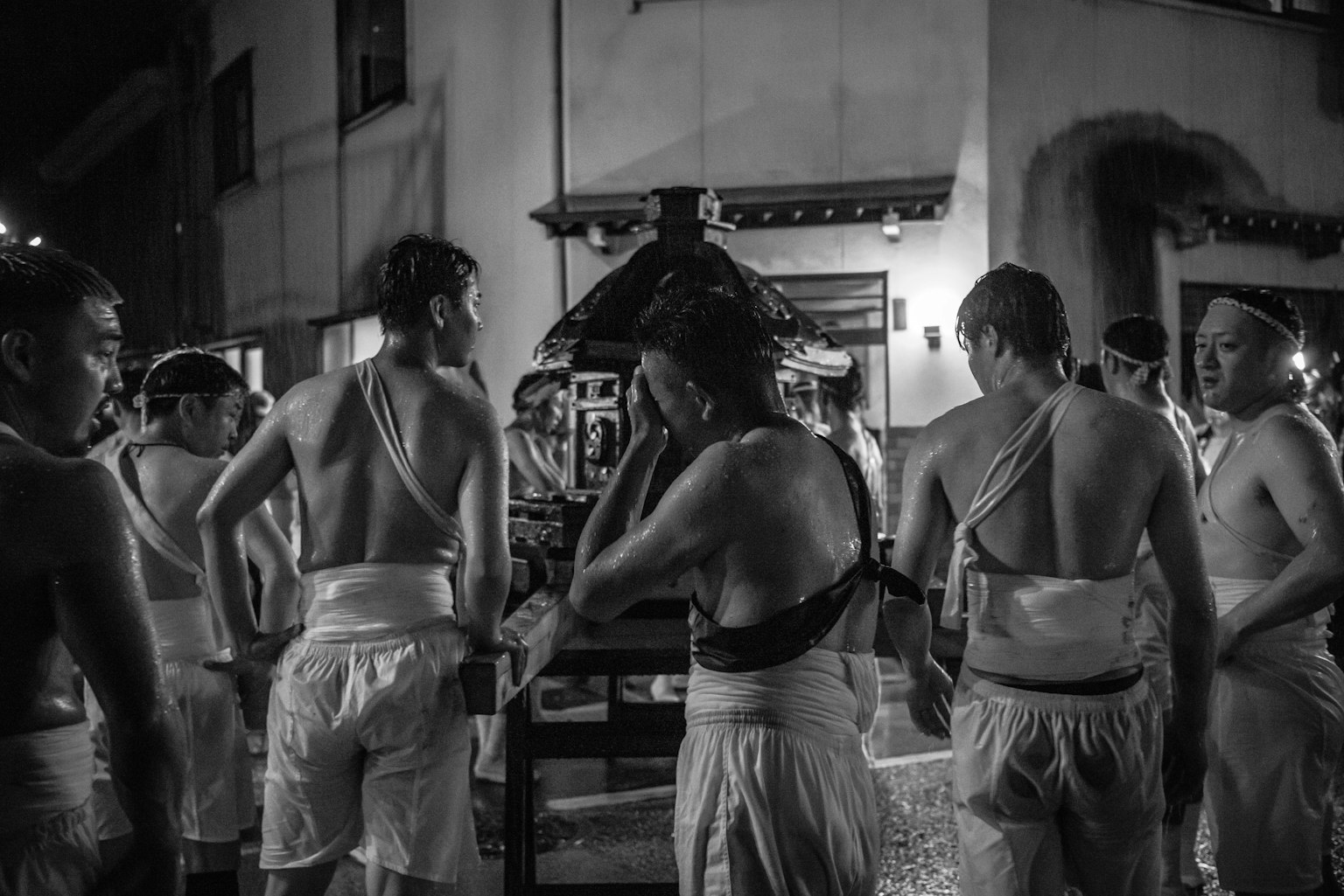 Men in white garments preparing a portable shrine