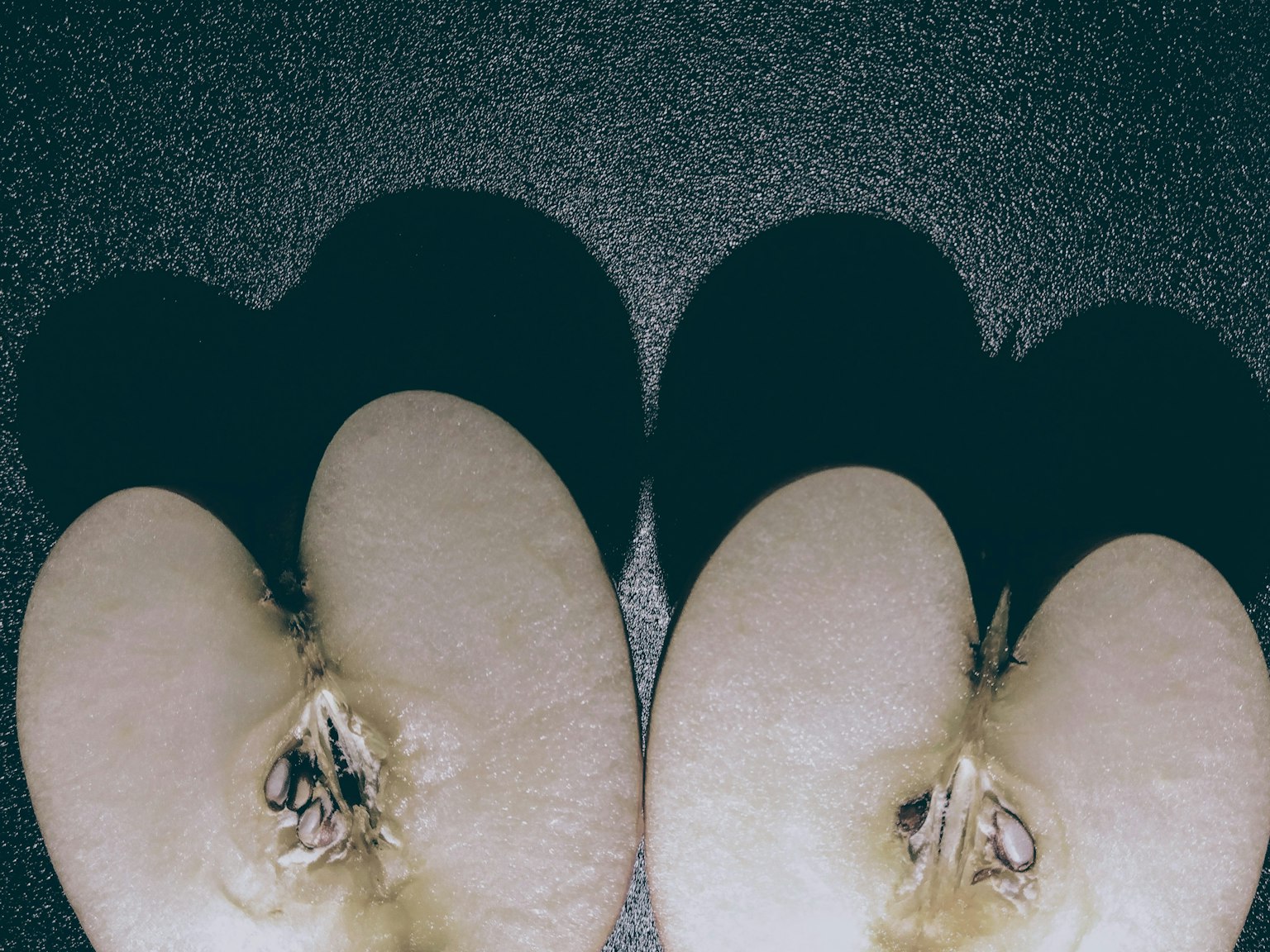 Pomme coupée en deux avec des ombres en forme de cœur