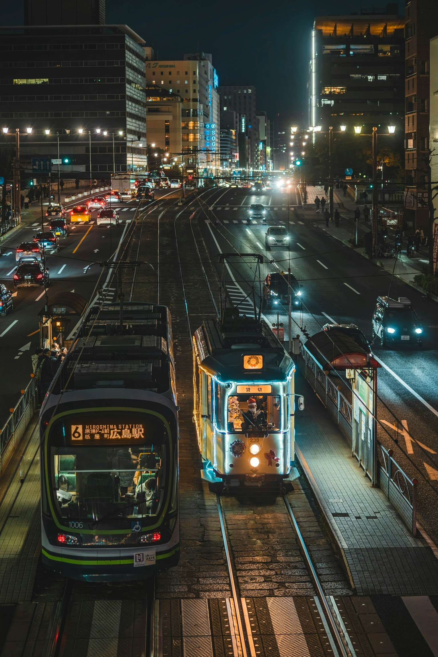 Night cityscape featuring trams and vehicles at a traffic intersection