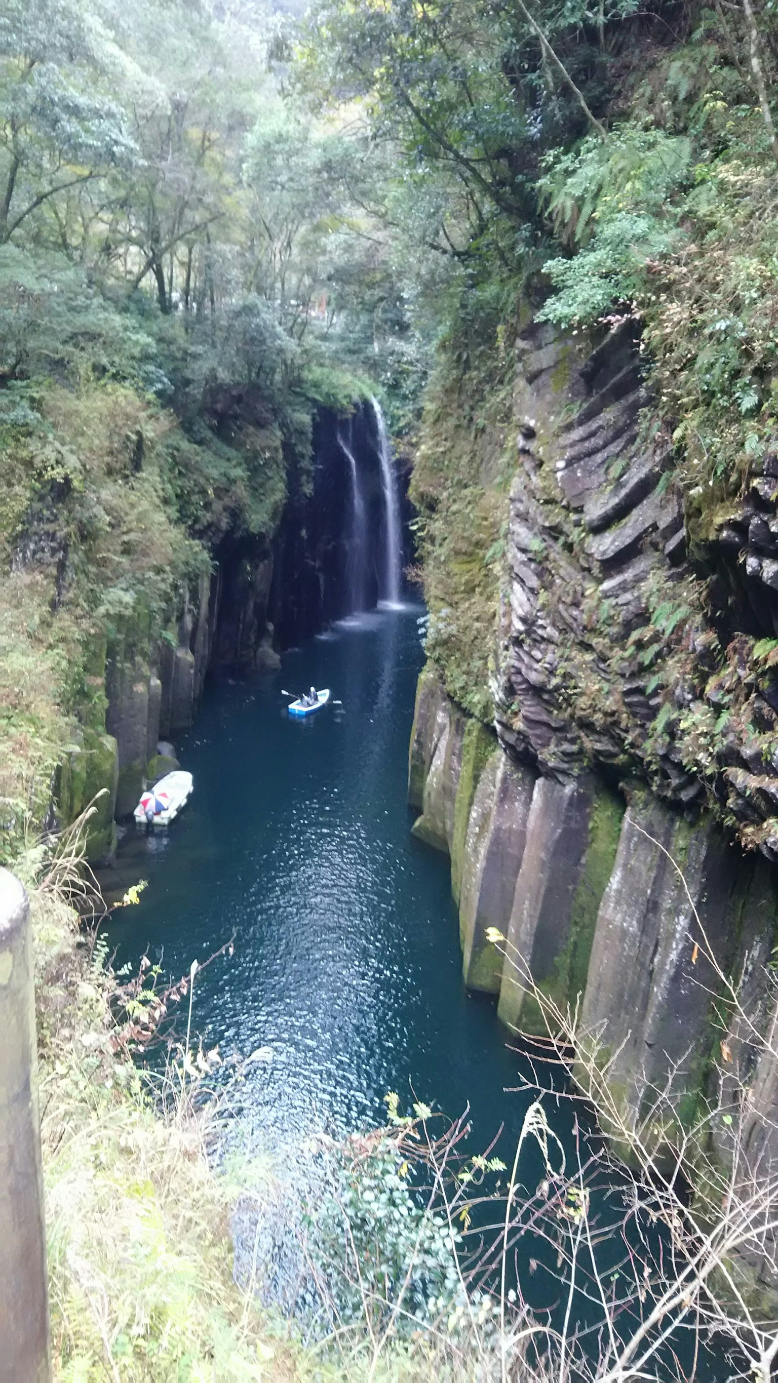 Scenic view of a waterfall flowing in a canyon with blue water