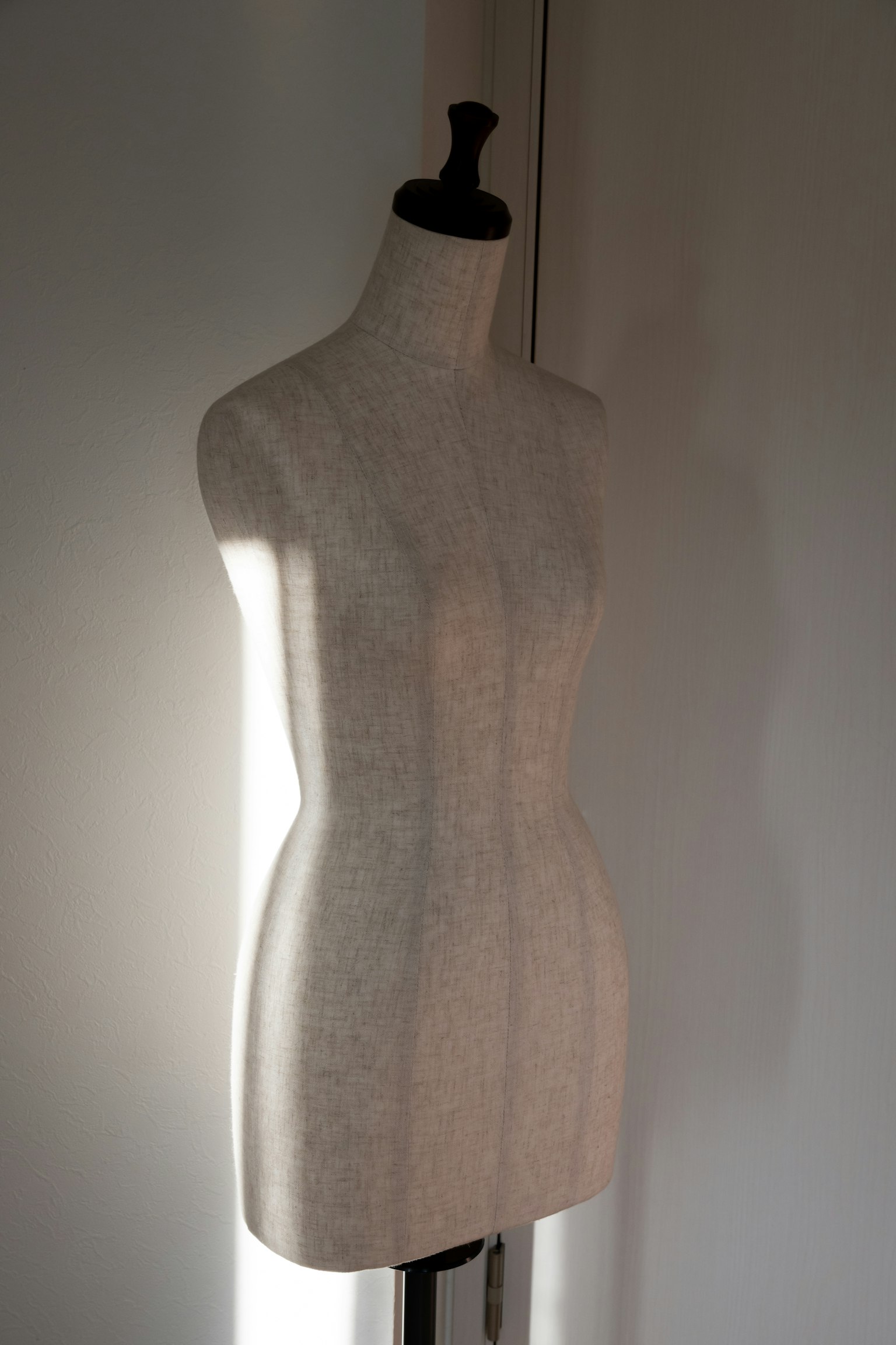 A dressmaker's mannequin standing in a well-lit room