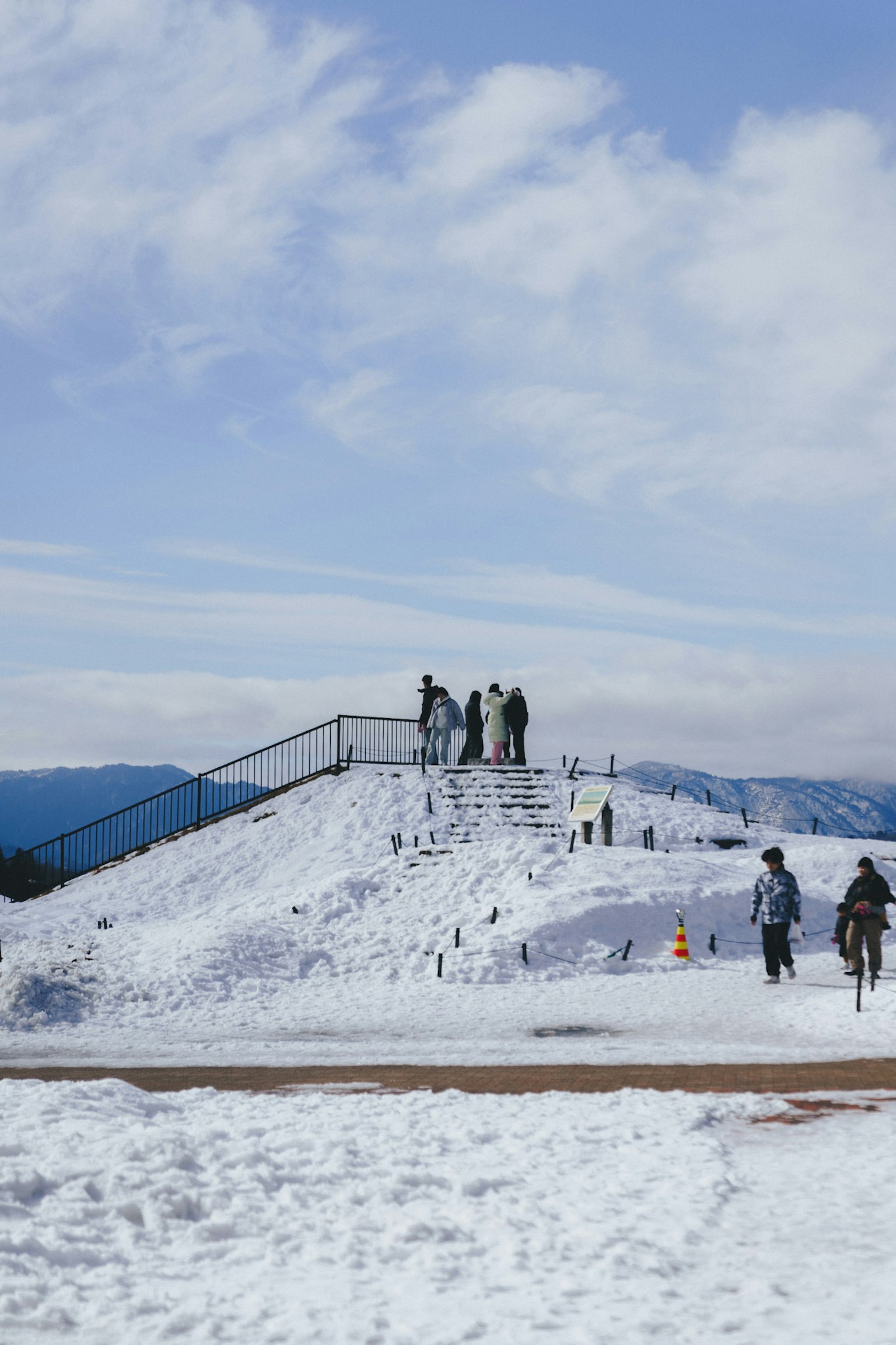 People standing on a snow-covered hill with a blue sky
