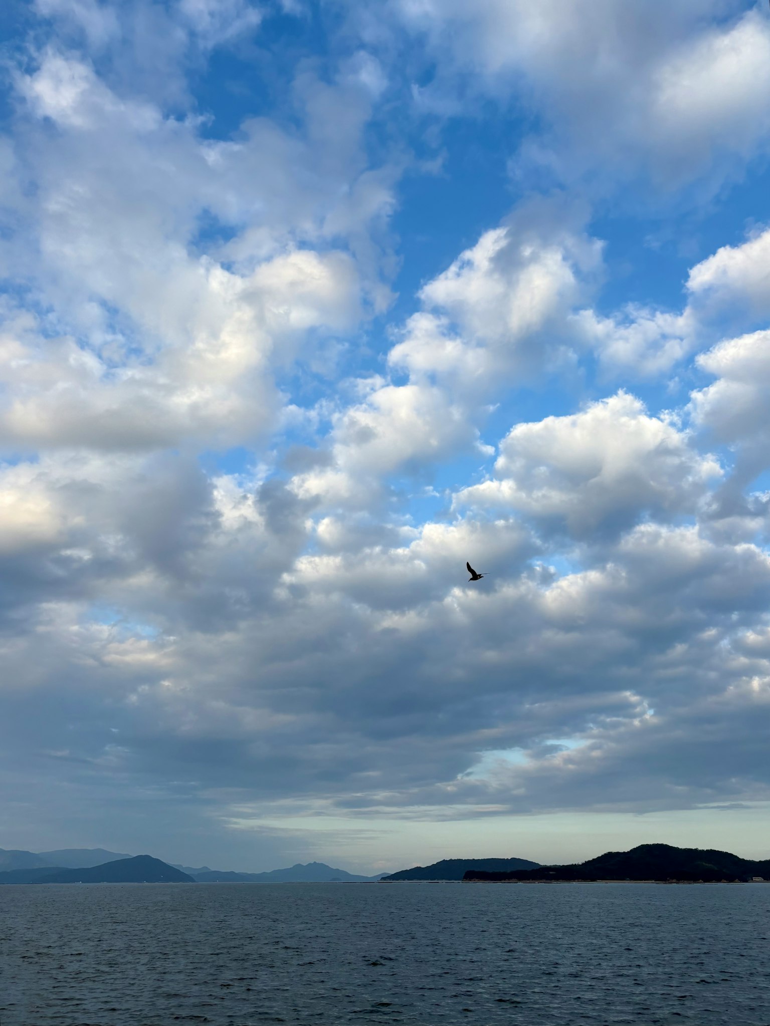 青い空と雲が広がる海の風景 島々が遠くに見える