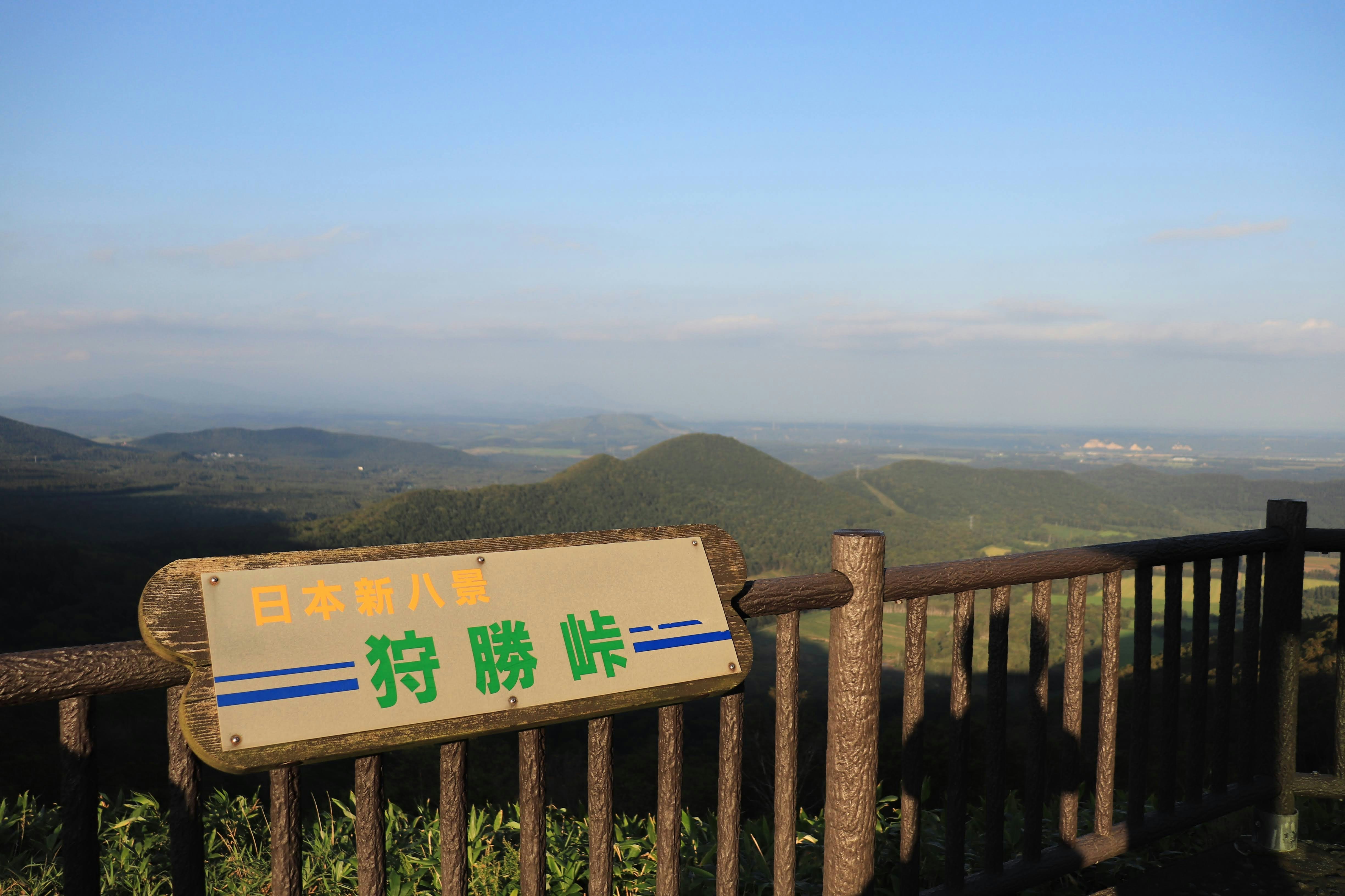 ป้ายบนราวกั้นจุดชมวิวที่เขียน “Japan’s No.1 Karikachi Pass” และวิวภูเขา