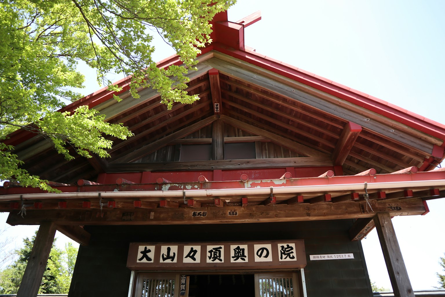 Extérieur d'un bâtiment traditionnel avec un toit rouge et une structure en bois