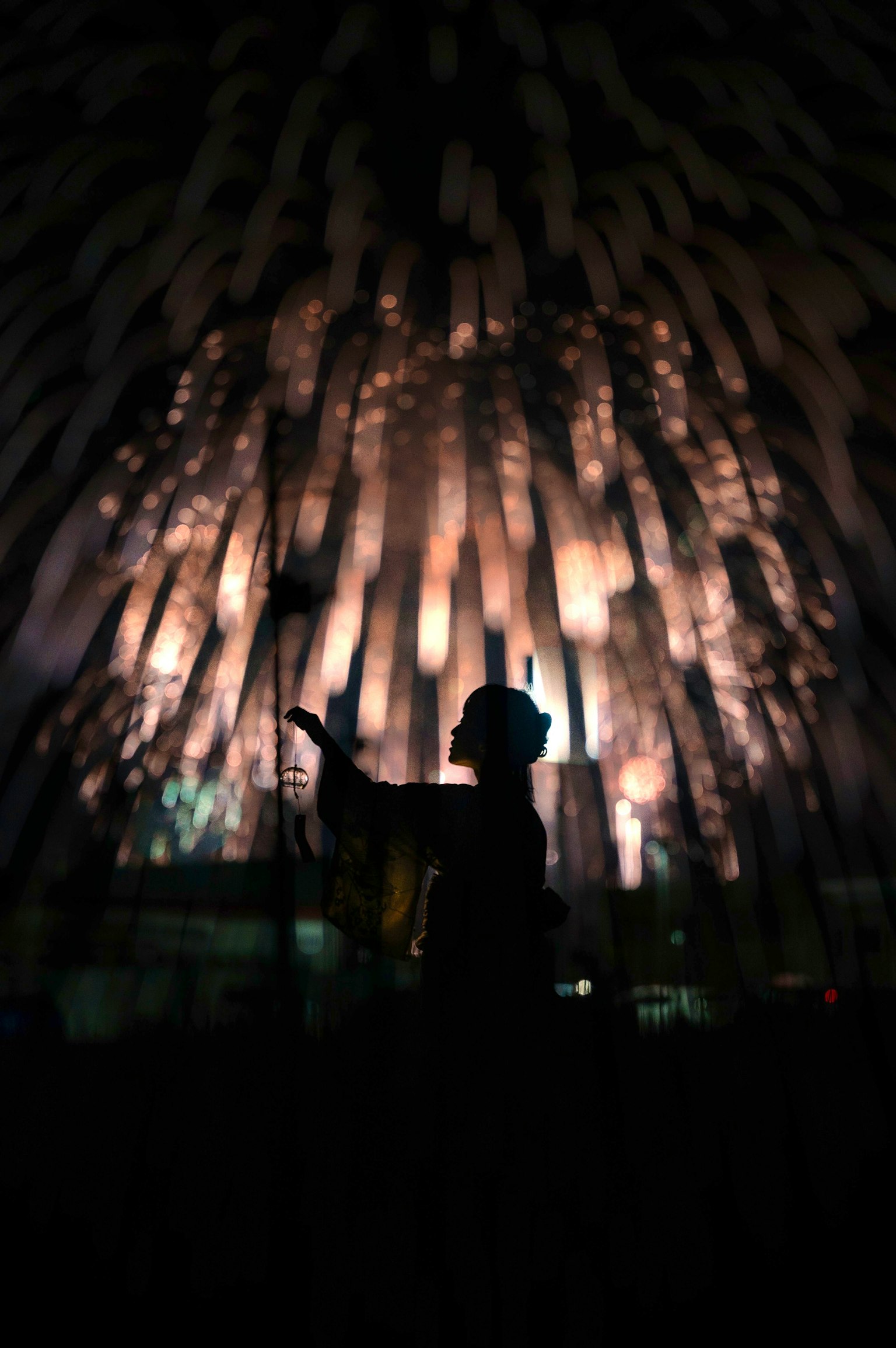 Silhouette of a person against a backdrop of illuminated vertical beams