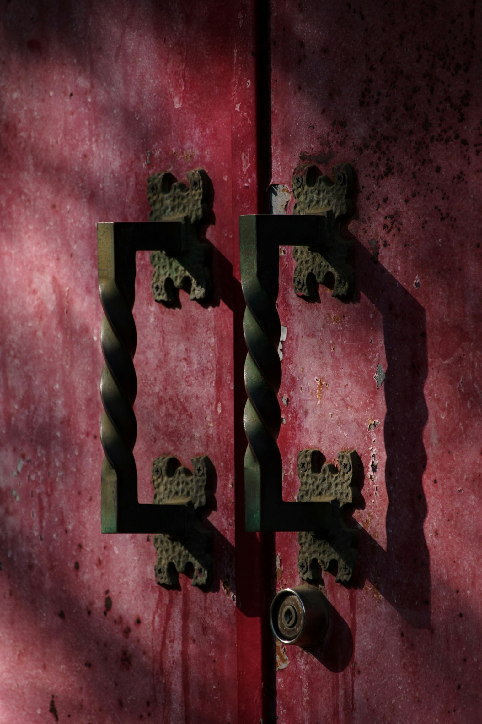 Maniglie nere decorative su una porta rossa