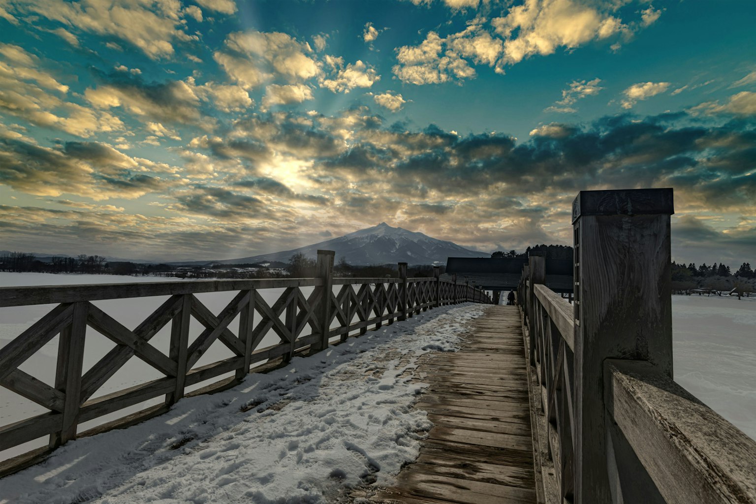 Schneebedeckter Weg mit einem lebhaften Himmel und Wolken