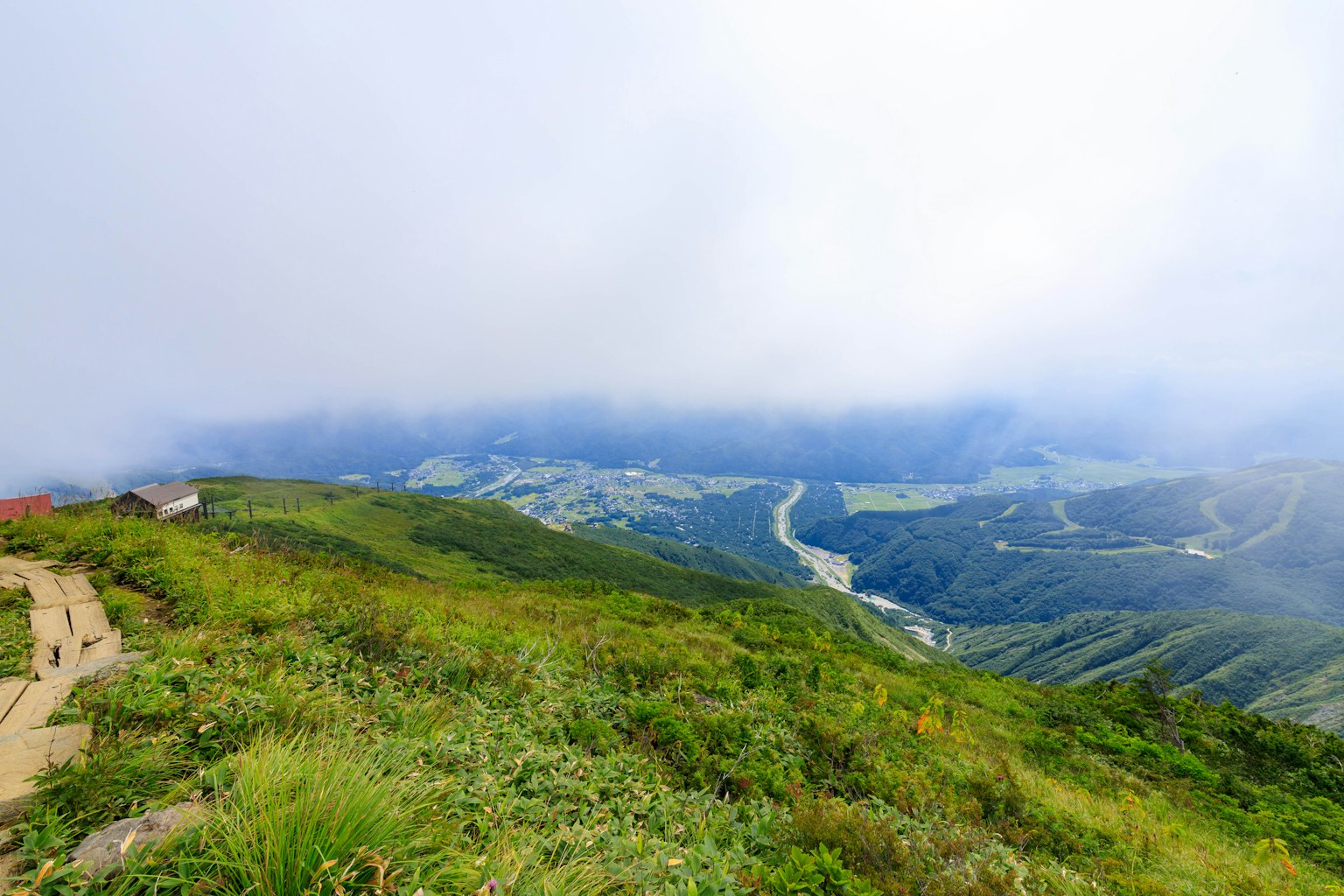 Vista escénica de colinas verdes y montañas brumosas