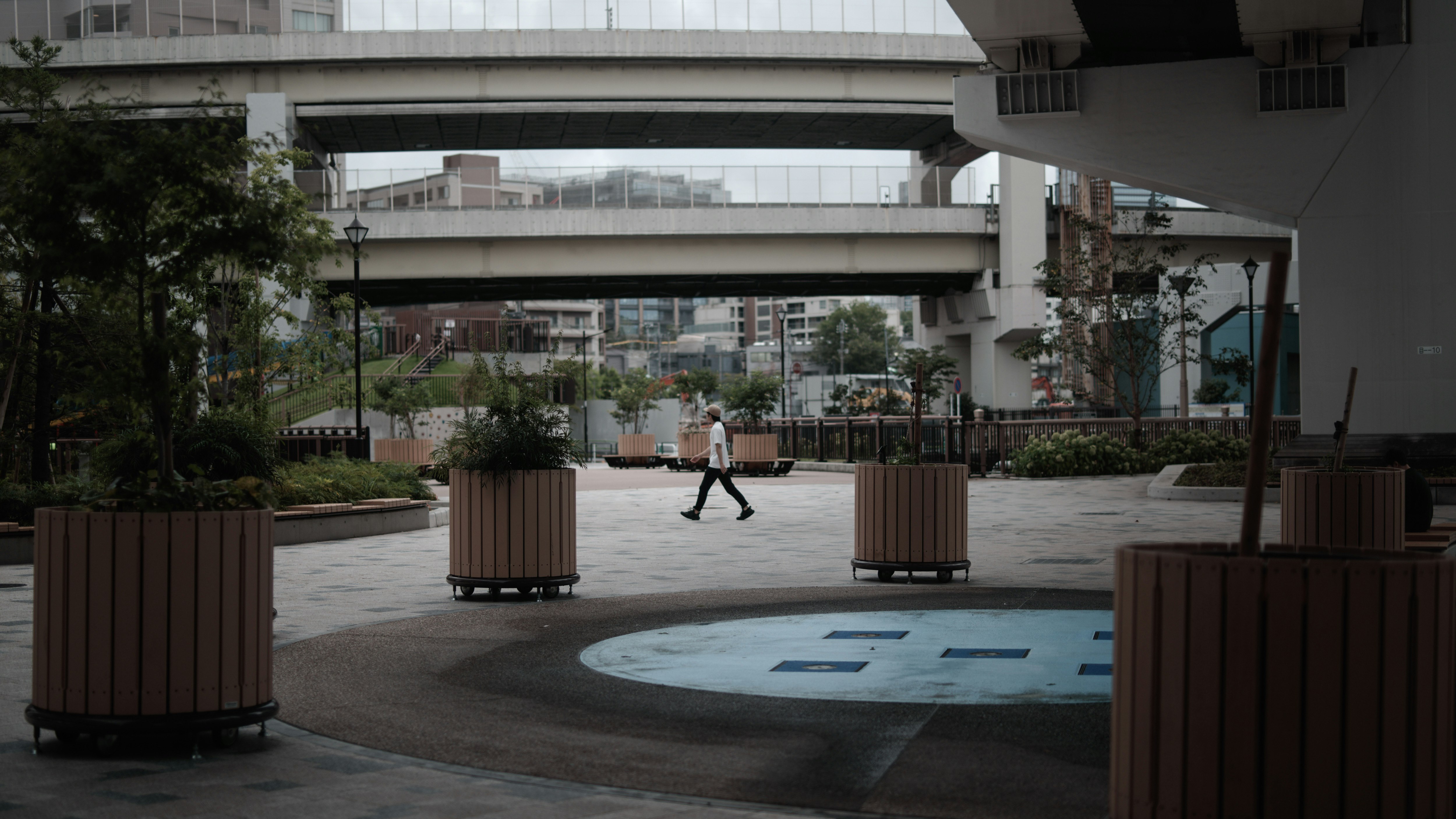 Outdoor courtyard scene with benches and planters in front of a modern building