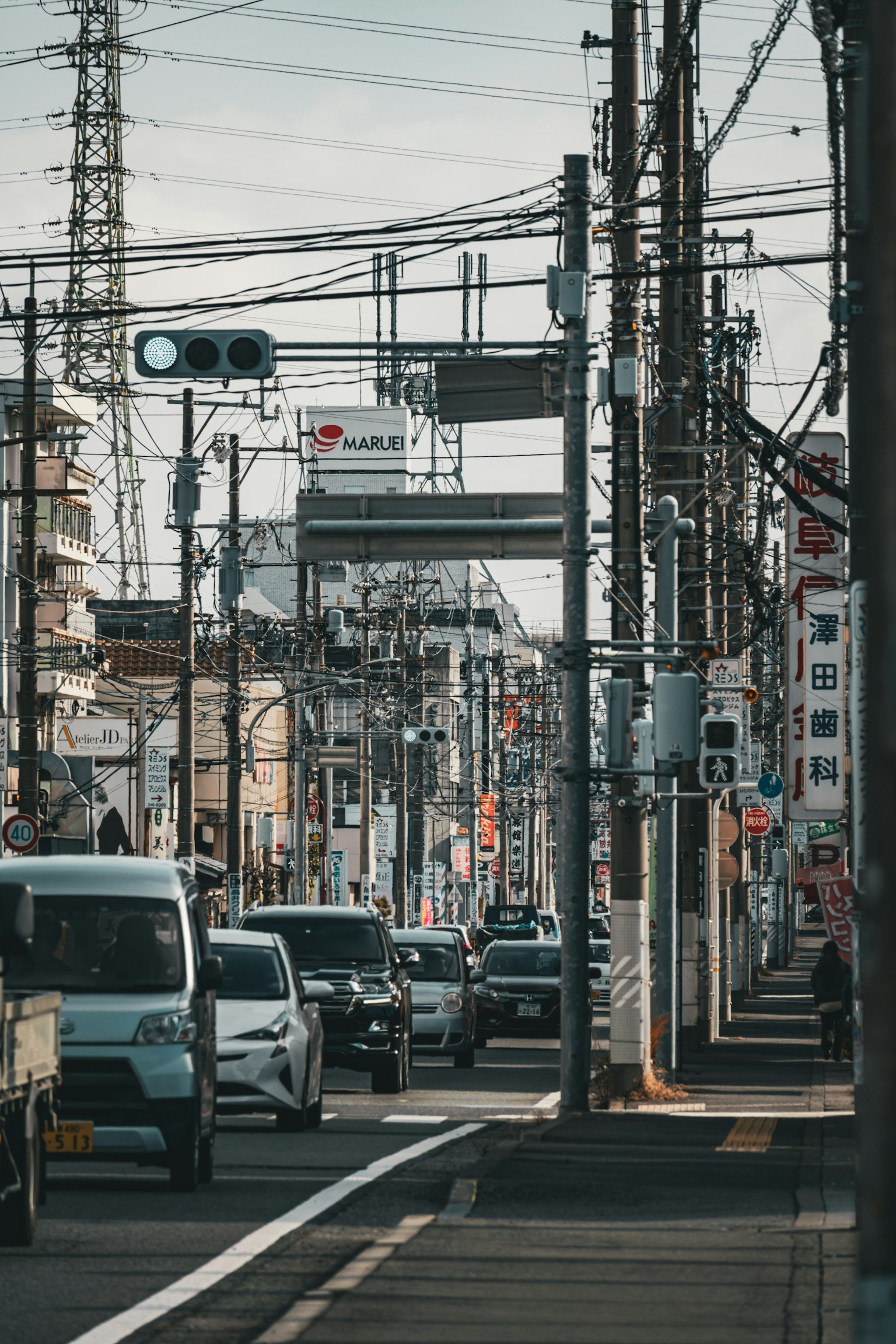 日本城市街道场景，包括车辆和电线
