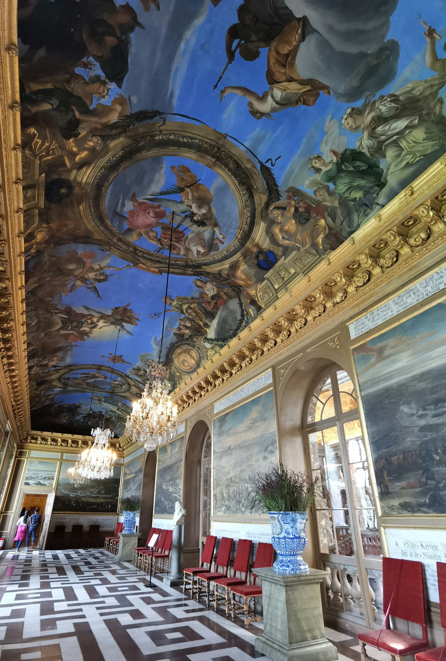 Interno lussuoso di una stanza con un bellissimo affresco blu sul soffitto sedie rosse e grandi finestre
