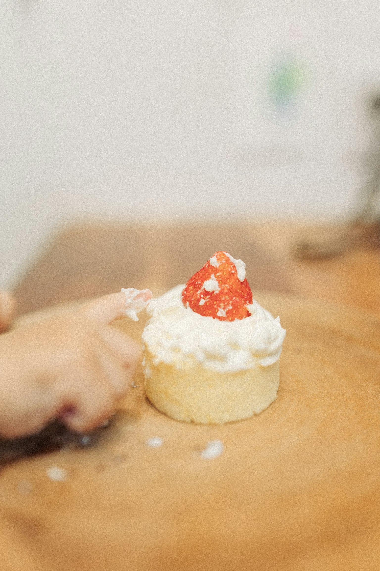 Un dito che tocca un cupcake con crema e fragola