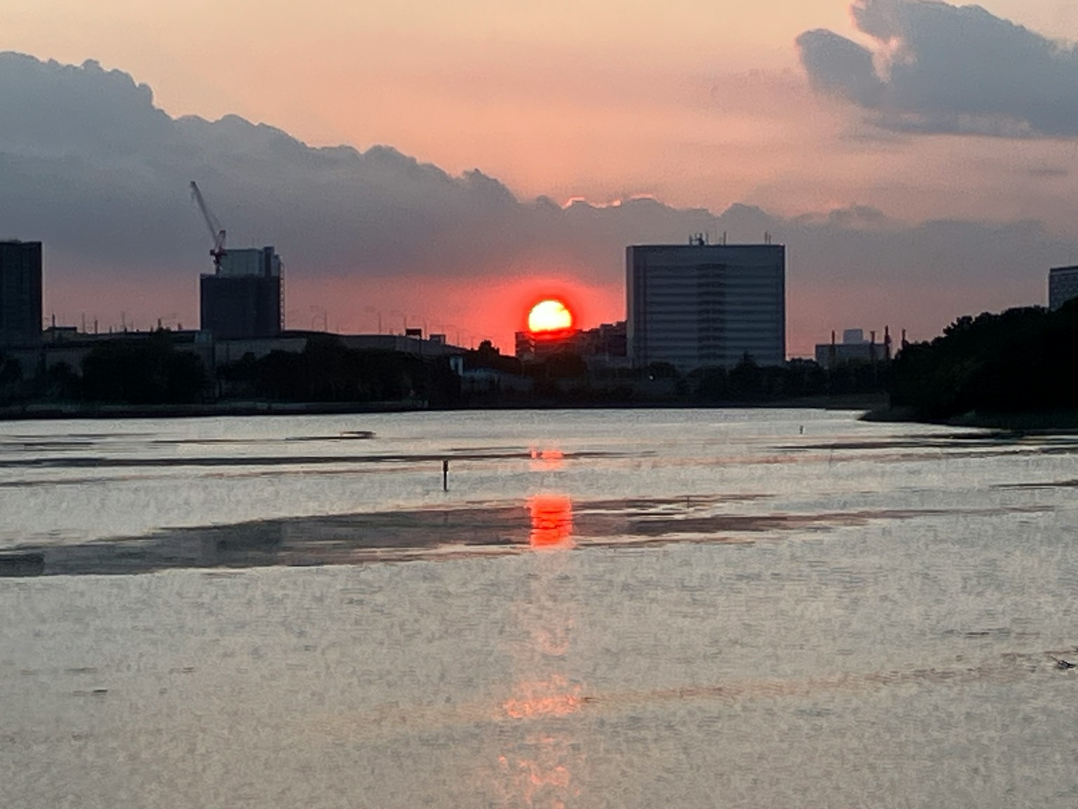 Meraviglioso paesaggio con il tramonto tra gli edifici che riflette una luce arancione sull'acqua