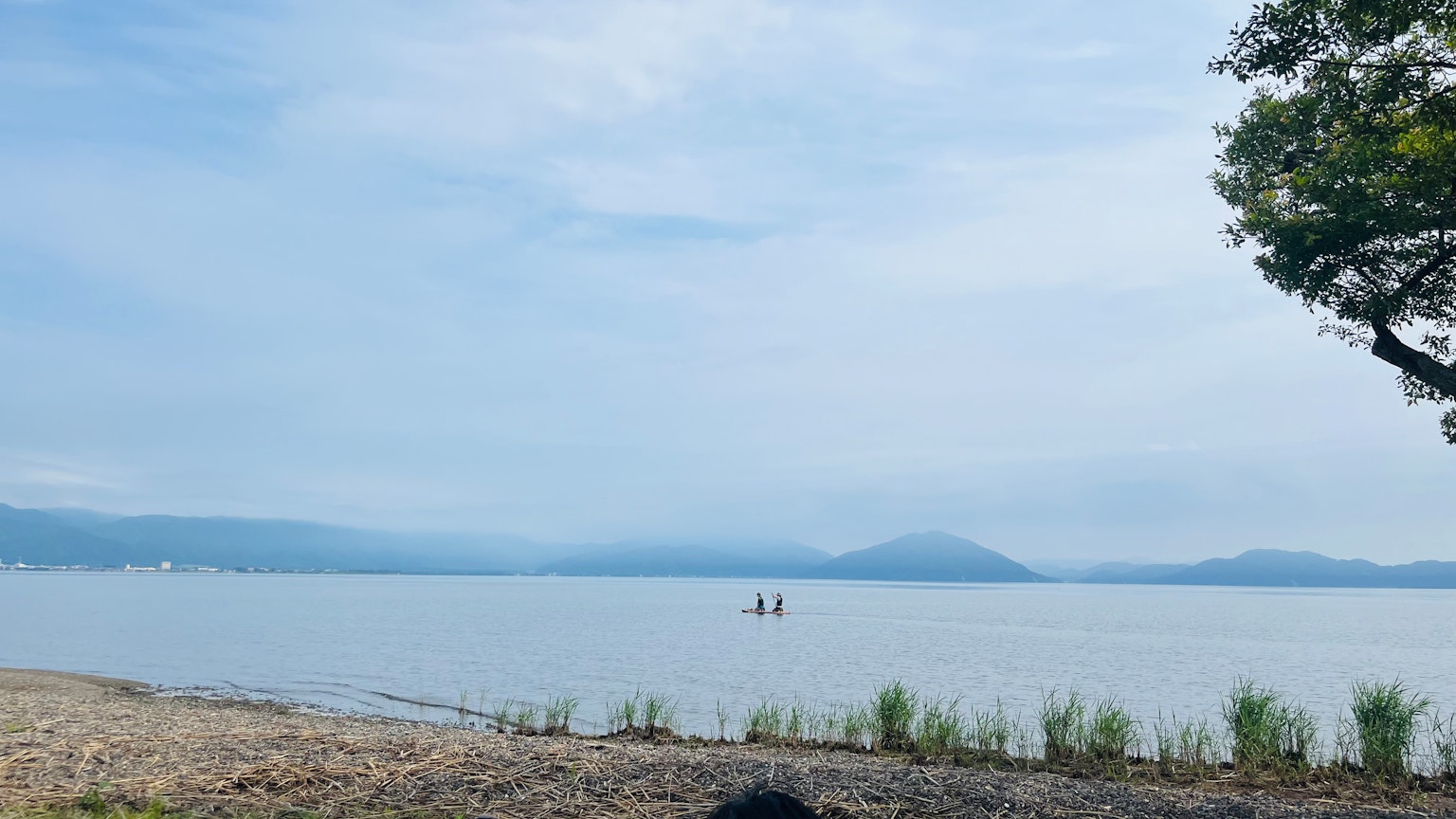 平静的湖泊风景，有人在划皮艇和远处的山脉
