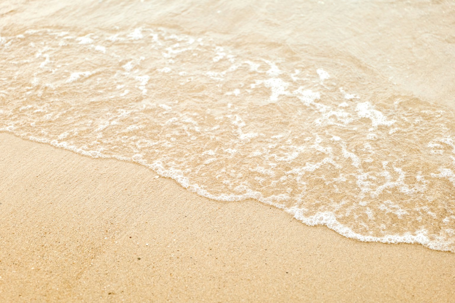 Vagues douces s'échouant sur une plage de sable