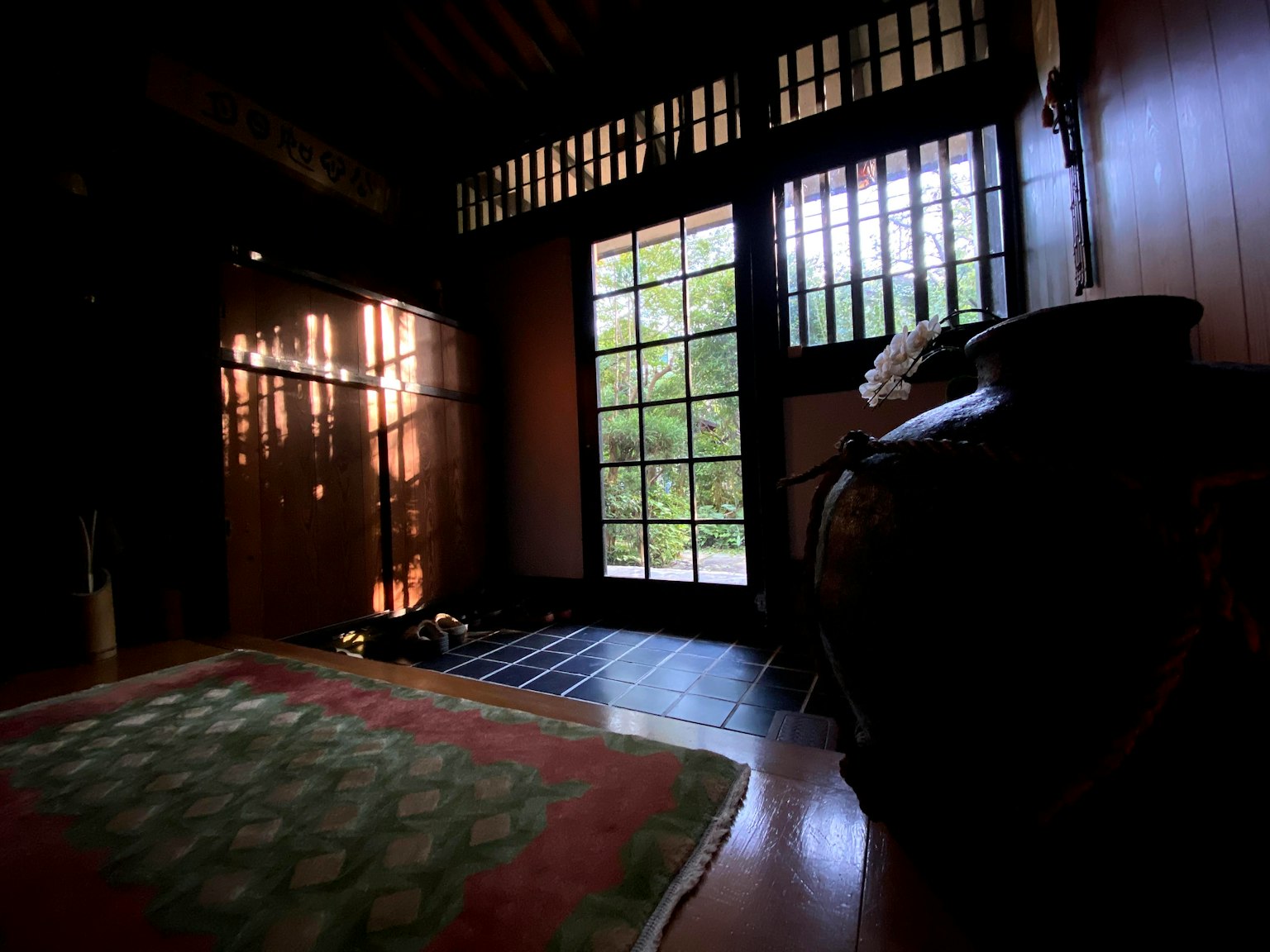 Traditional Japanese room interior with wooden walls shoji windows and green carpet natural light streaming in