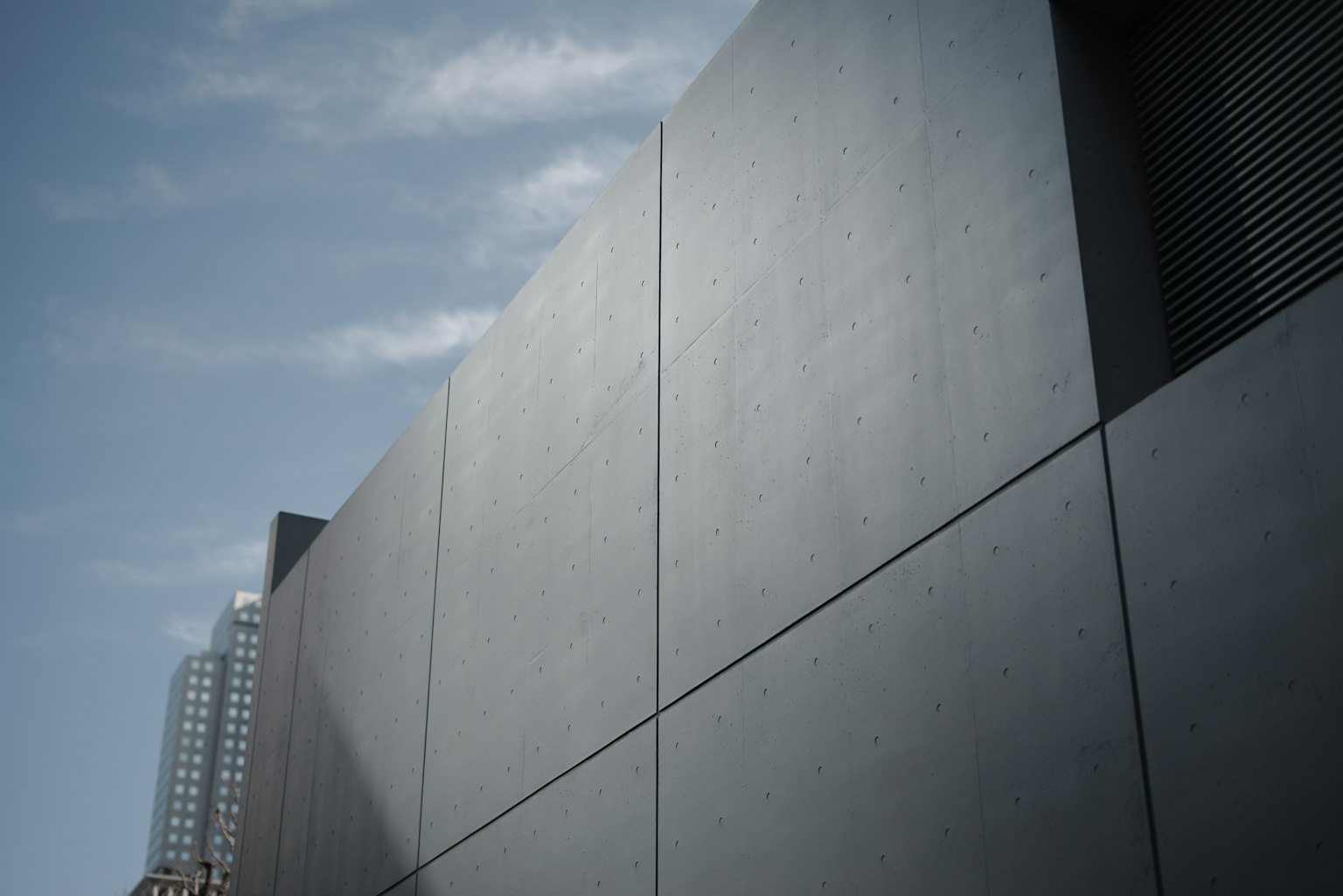 Parete di un edificio moderno grigio con cielo blu