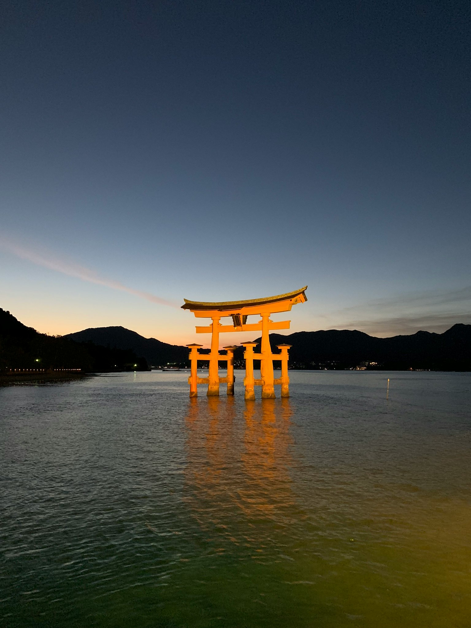 Cổng Torii của đền Itsukushima nổi trên biển lúc hoàng hôn
