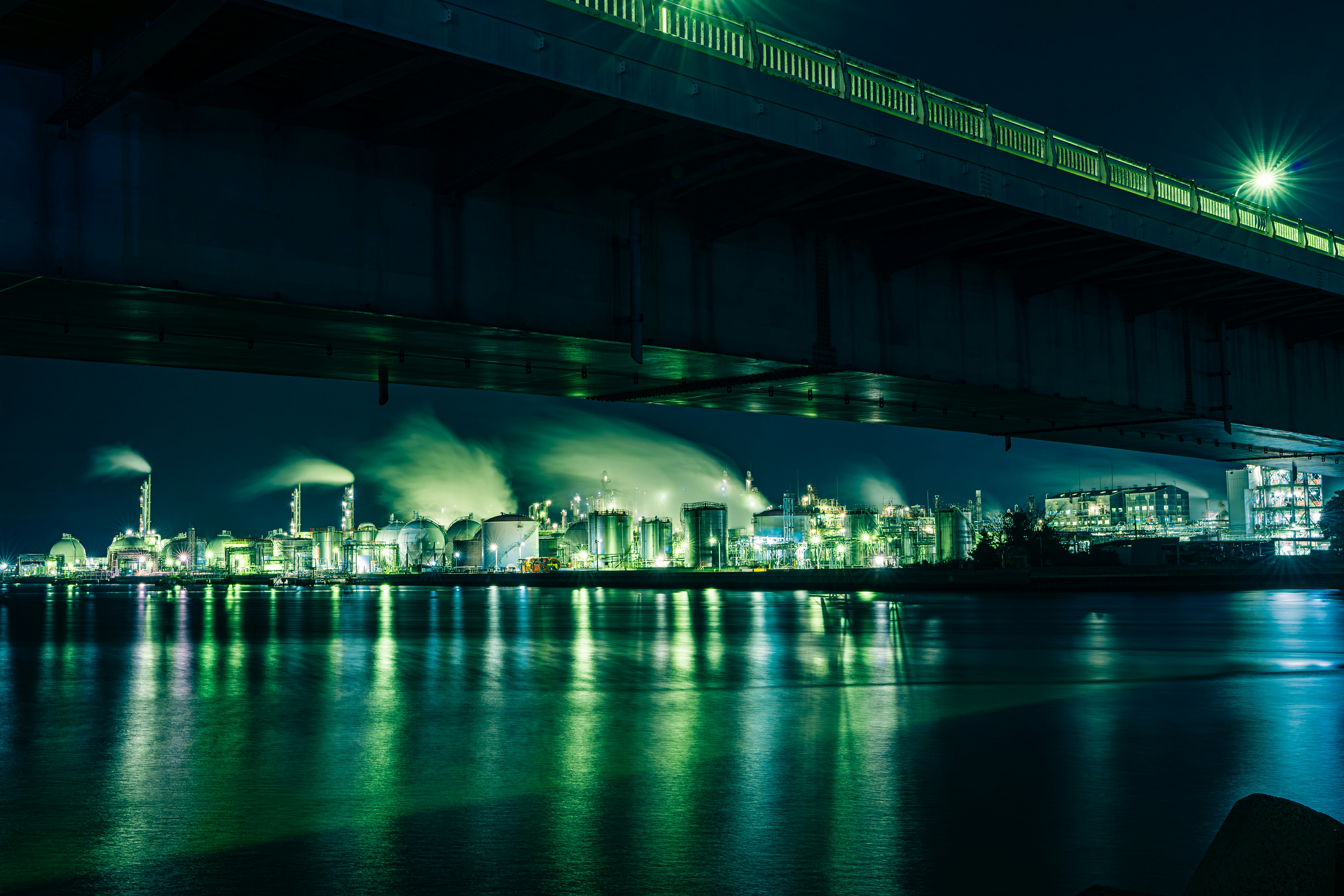 夜の川沿いに広がる工業地帯の夜景