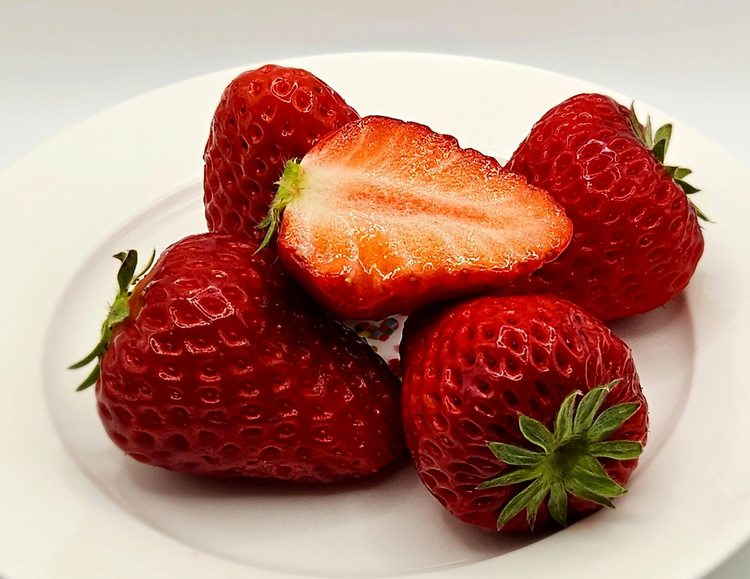 Une collection de fraises fraîches sur une assiette blanche