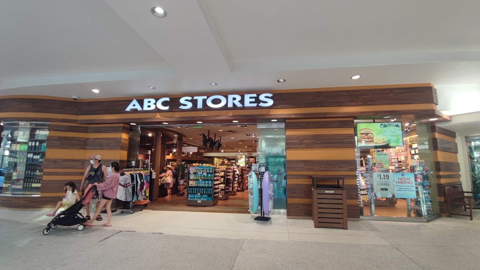 Außenansicht der ABC Stores mit Holzfassade und Käufern