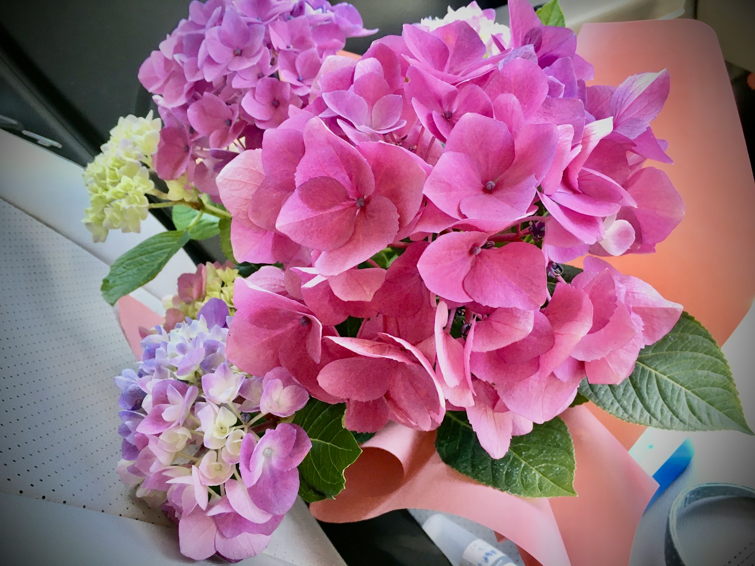 Un bellissimo bouquet di ortensie viola avvolto in carta rosa