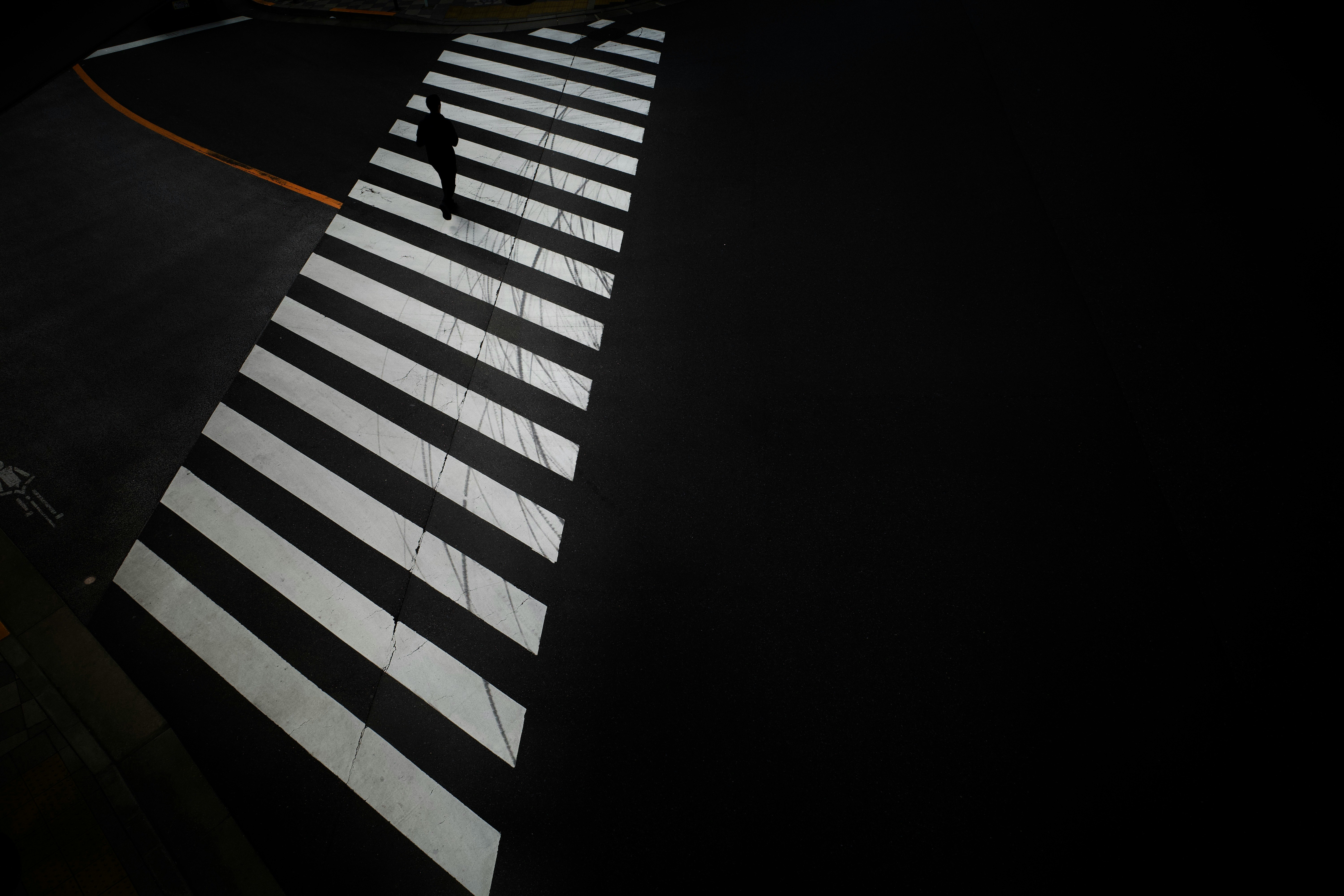 黒い背景に白い横断歩道のストライプが見える