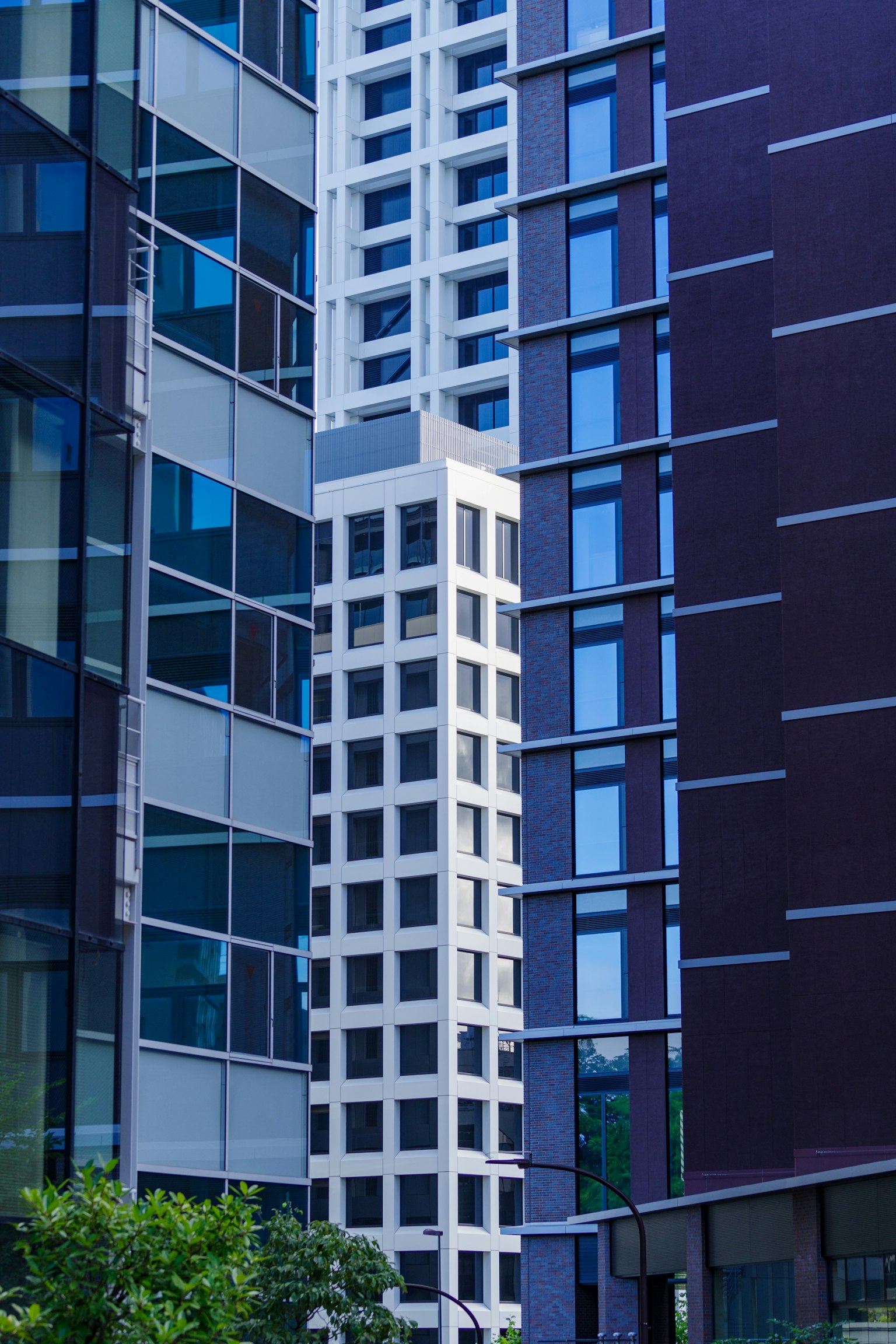 Ein weißes Hochhaus, das zwischen modernen Glasbauten steht