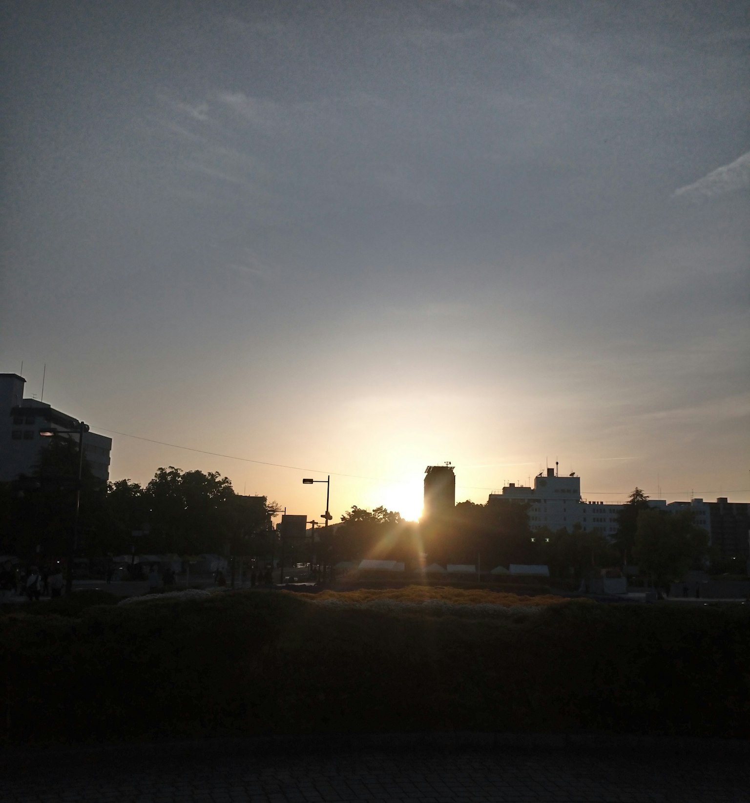Paisaje urbano con una puesta de sol visible entre los edificios