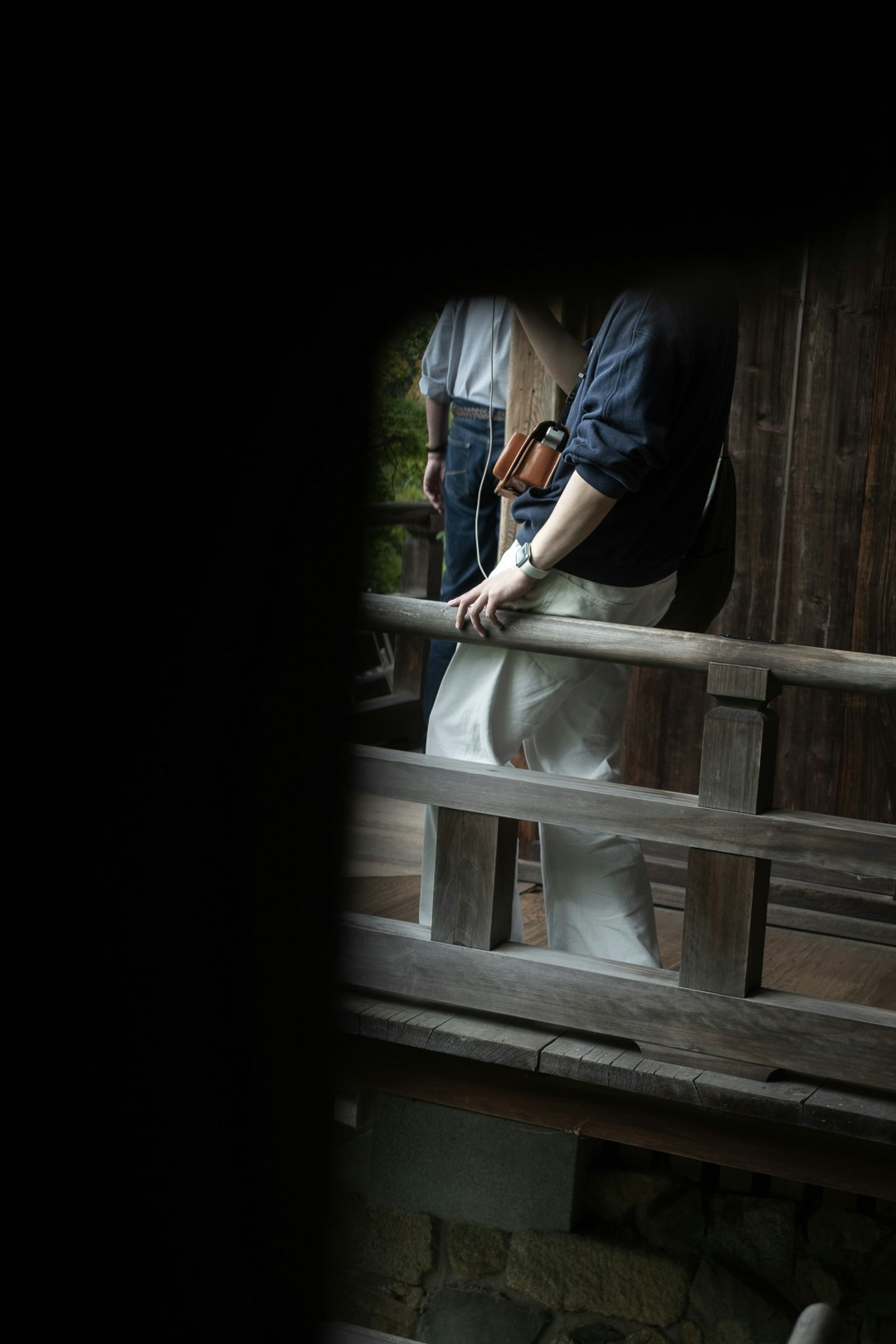 hands working in front of a wooden fence